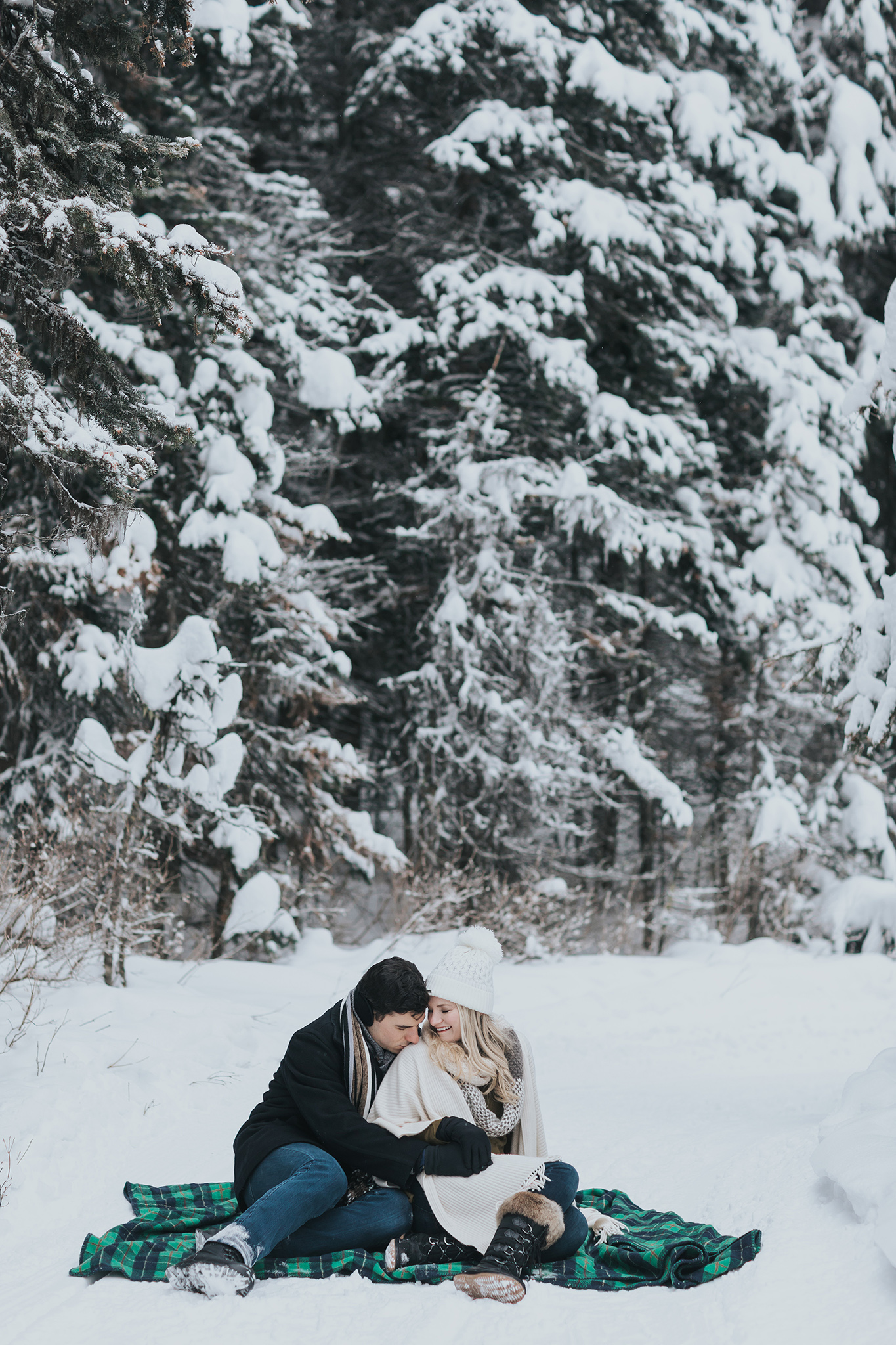 cuddly couples session in the snow during winter. Woodland forest couples pictures