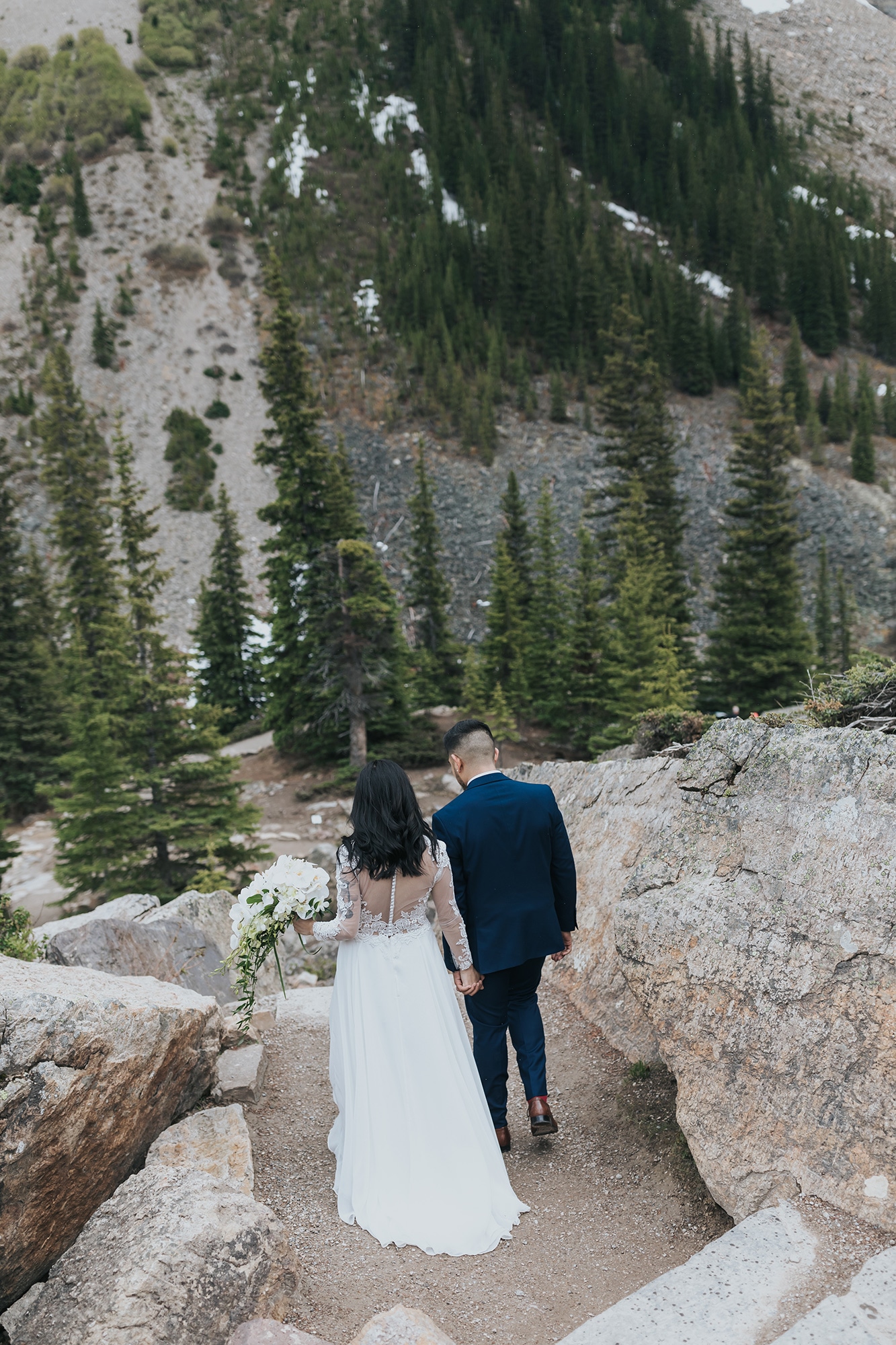 Summer Lake Louise Elopement moraine lake mountain wedding in late spring at the Rock Pile in Moraine Lake with snowy mountains