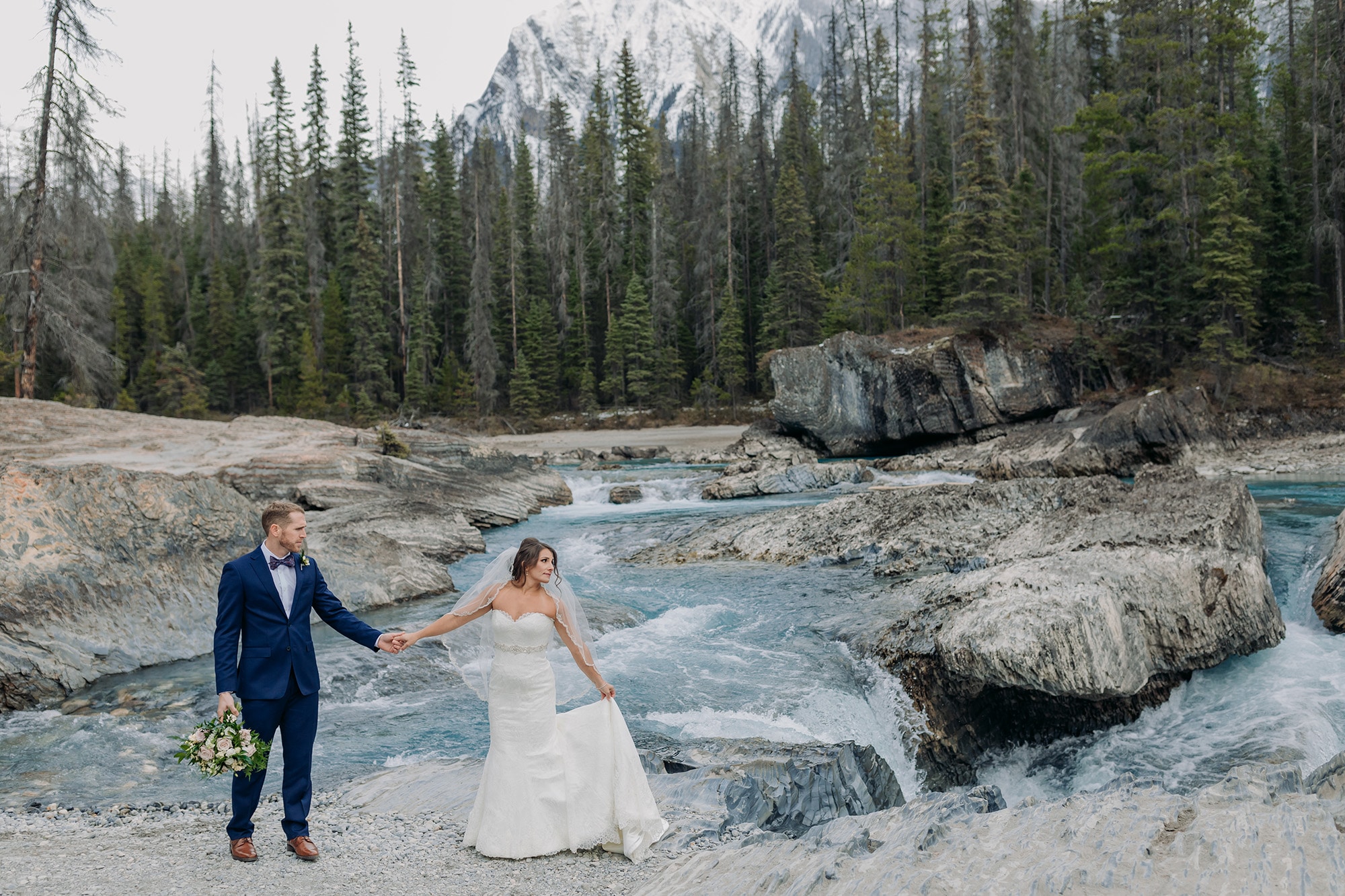 wedding photos in October at the Natural Bridge in Yoho National Park with gorgeous blue water
