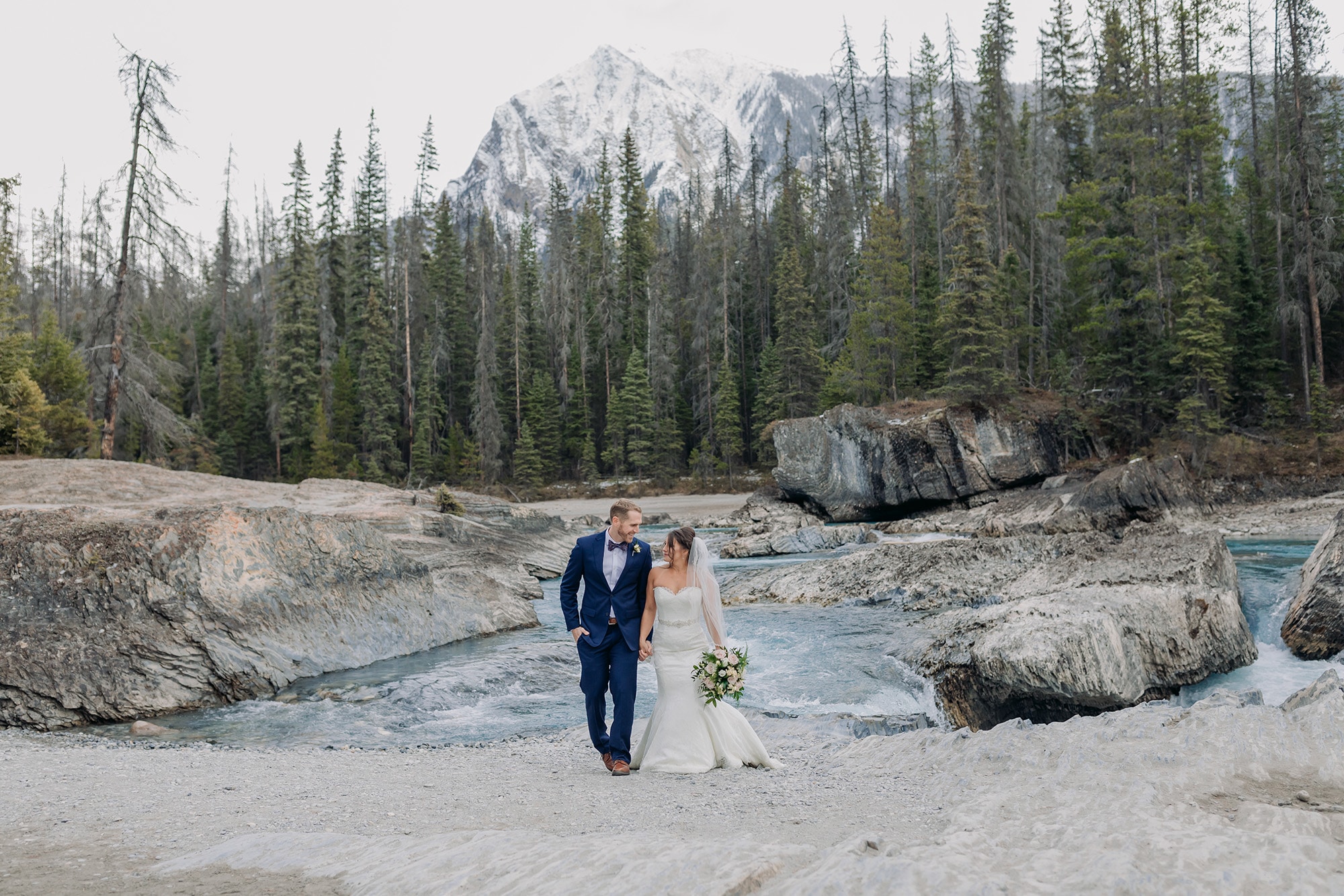 wedding photos in October at the Natural Bridge in Yoho National Park with gorgeous blue water
