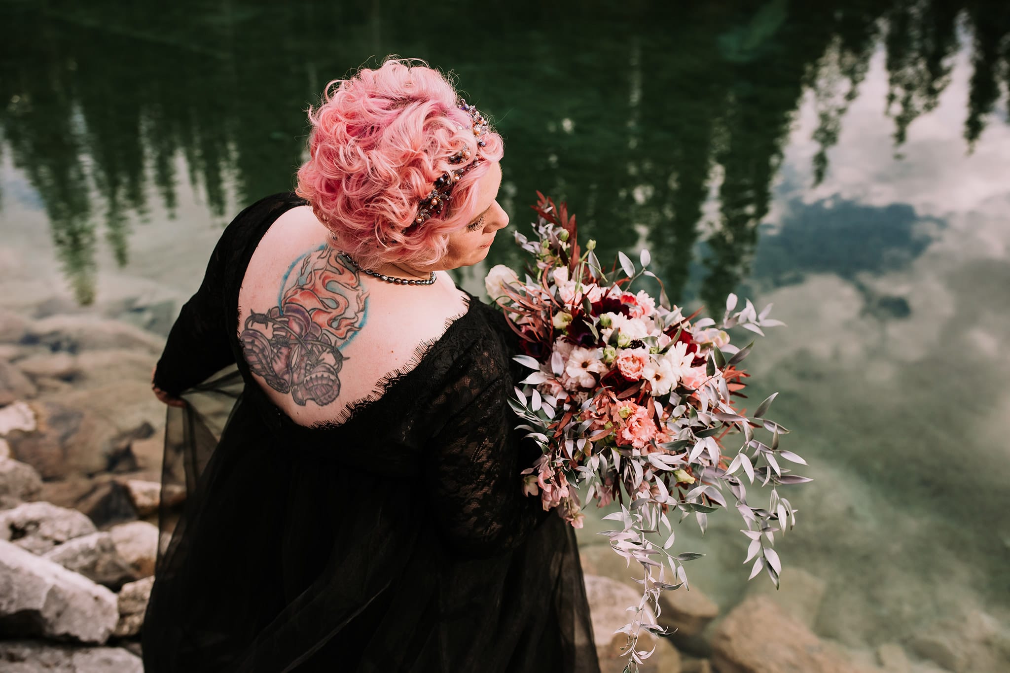 tattooed plus size bride n black wedding gown with pink hair dark moody wedding bouquet at Emerald Lake