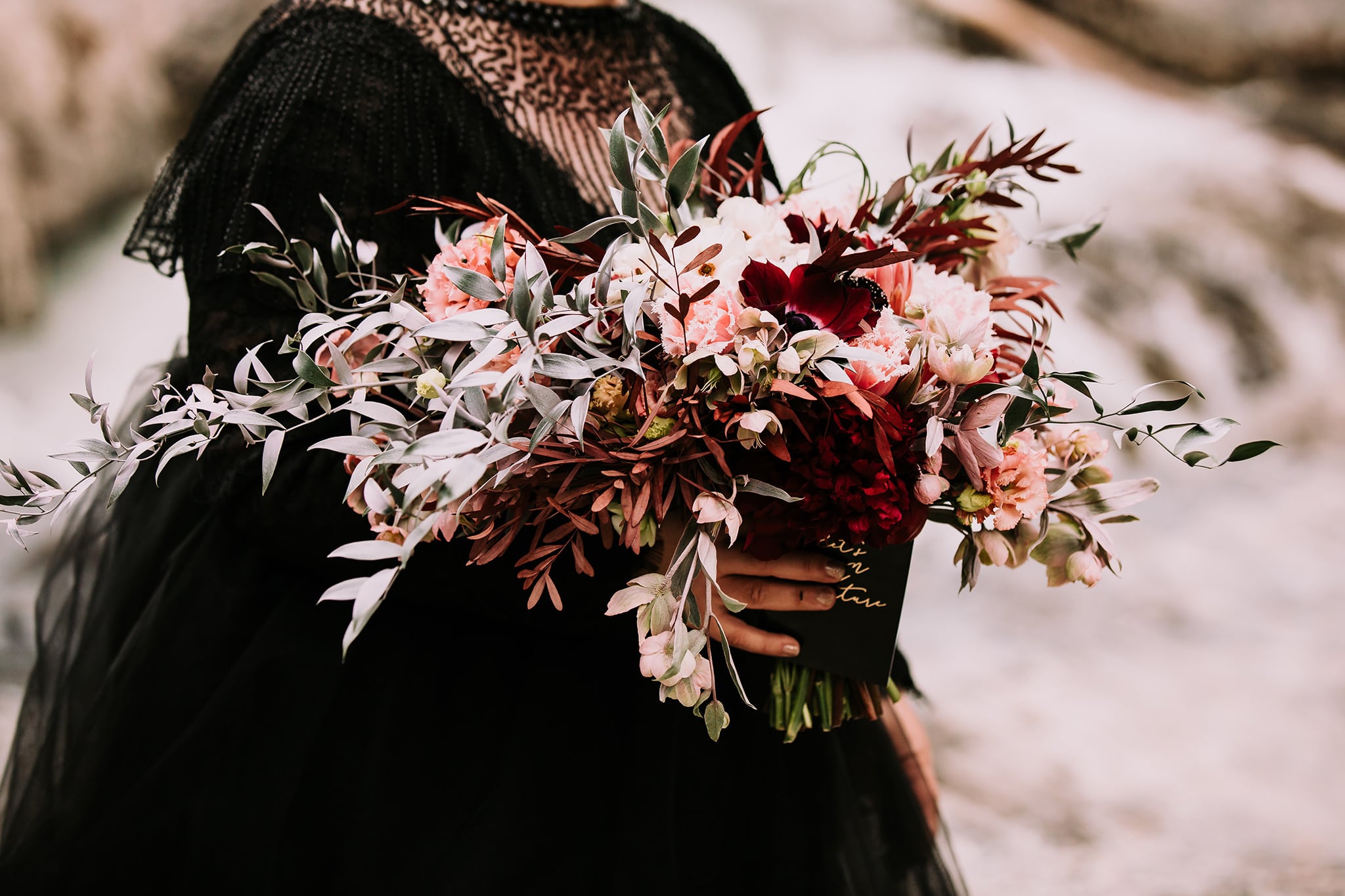 dream mountain vow renewal natural bridge yoho national park bride in black wedding gown with wild dark moody wedding flowers