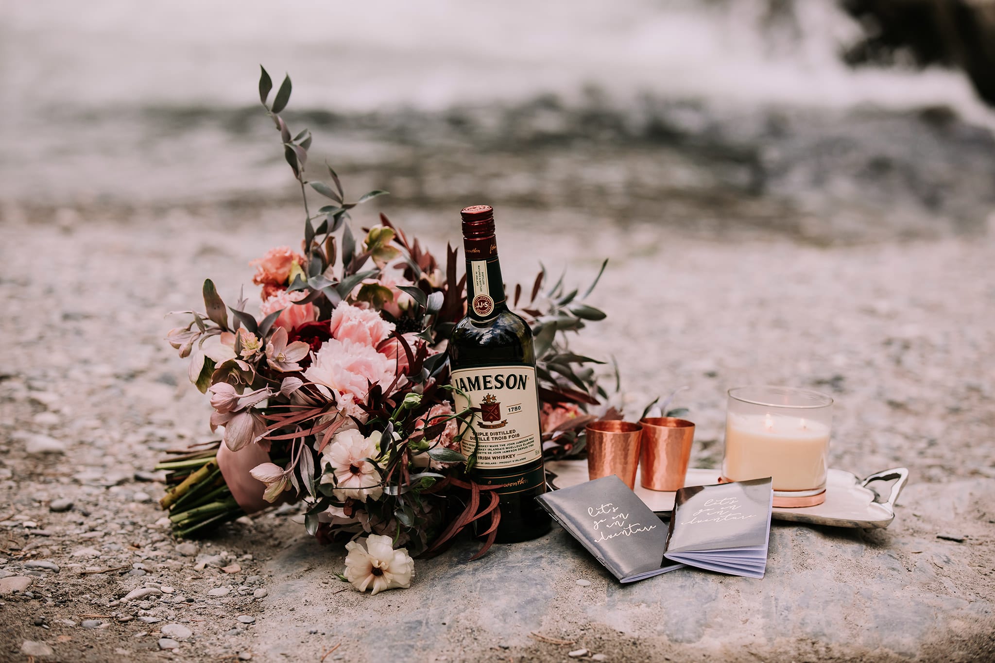 dream mountain vow renewal details with vow books, copper shot glasses, candle, jameson & dark moody wedding bouquet