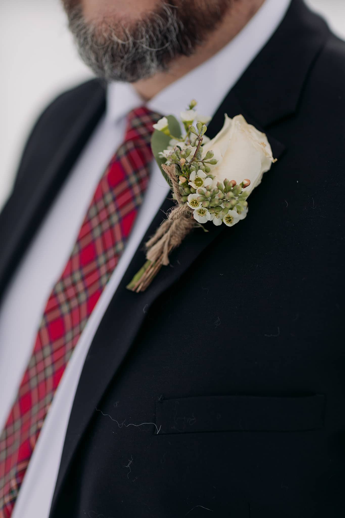 boutonniere in white & green with red plaid tie