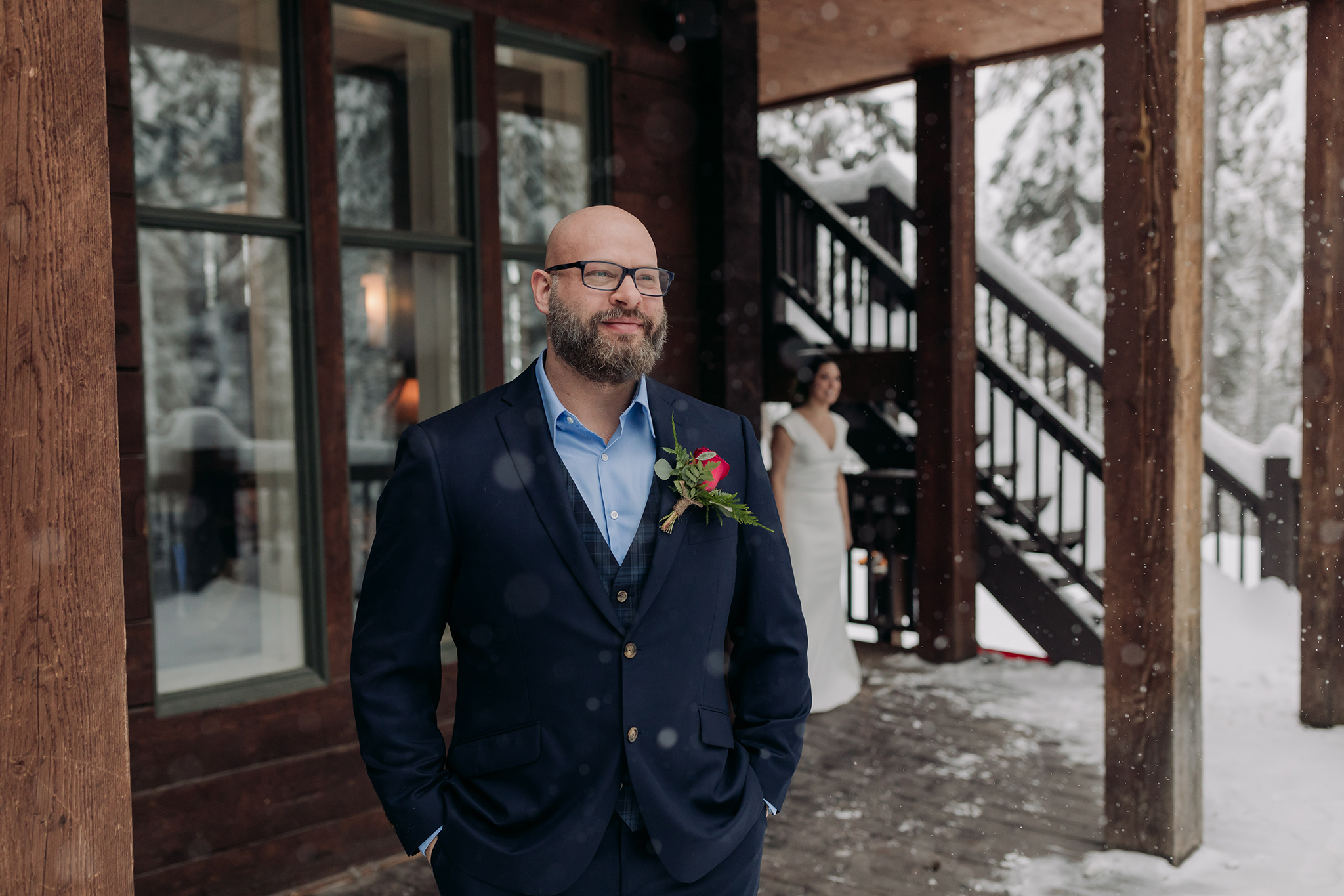 Emerald Lake Lodge winter elopement Bride & Groom first Look on the deck at the Main lodge with icicles & falling snow photographed by mountain elopement & wedding photographer ENV Photography