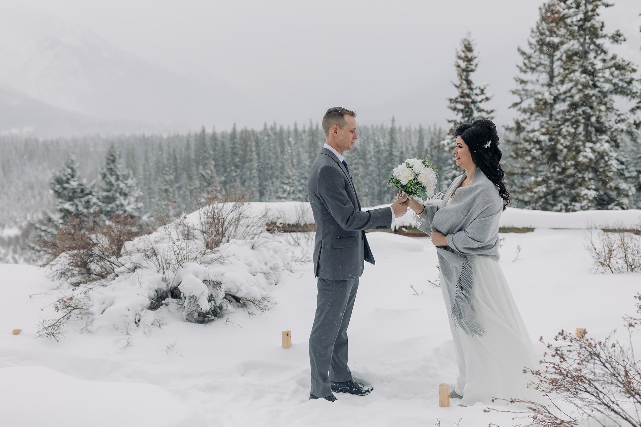 wedding first look at Juniper Hotel in Banff National Park in a snow storm photographed by ENV Photography