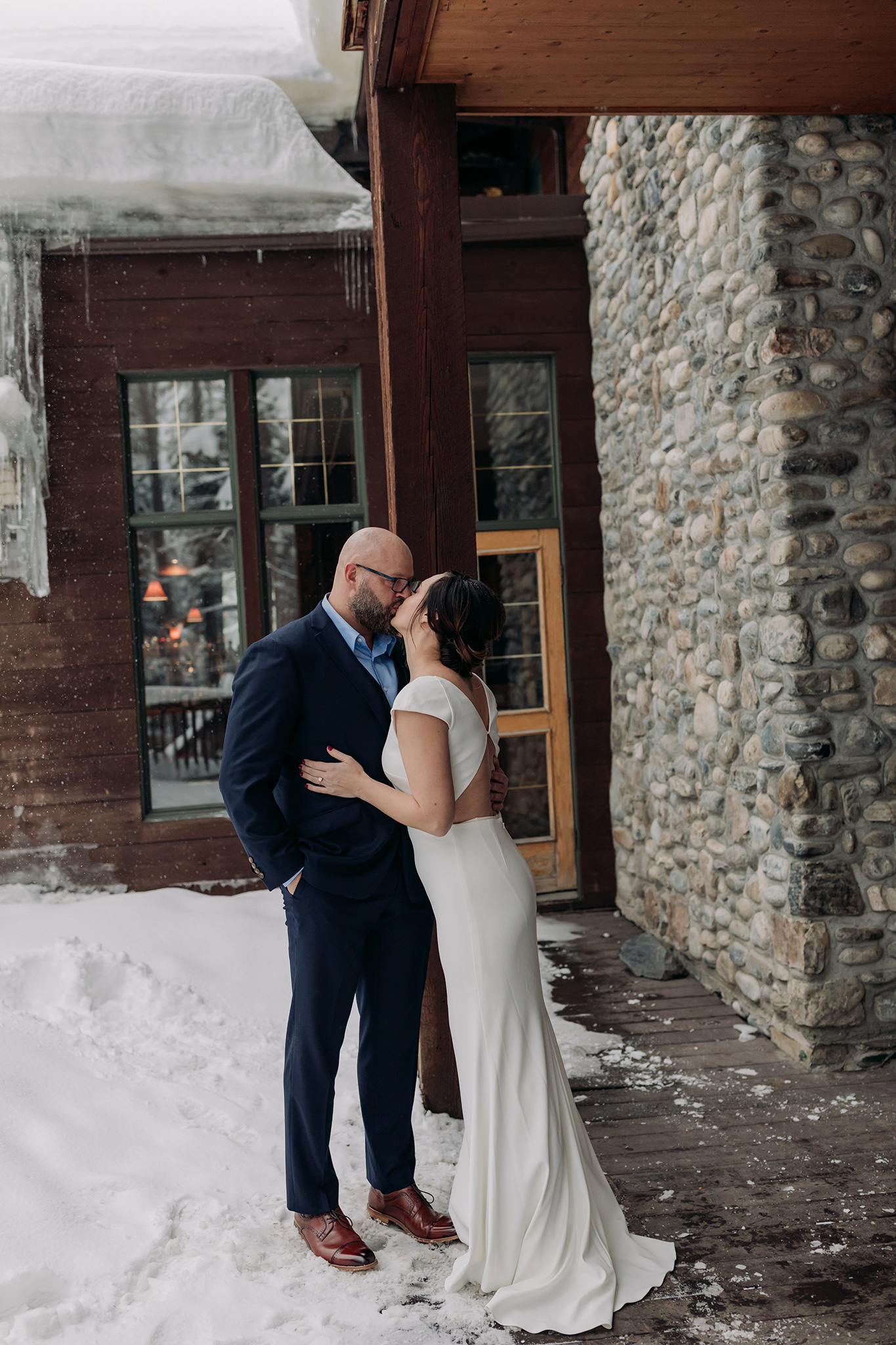 elopement Bride & Groom first Look on the deck at the Main lodge with icicles & falling snow photographed by mountain elopement & wedding photographer ENV Photography