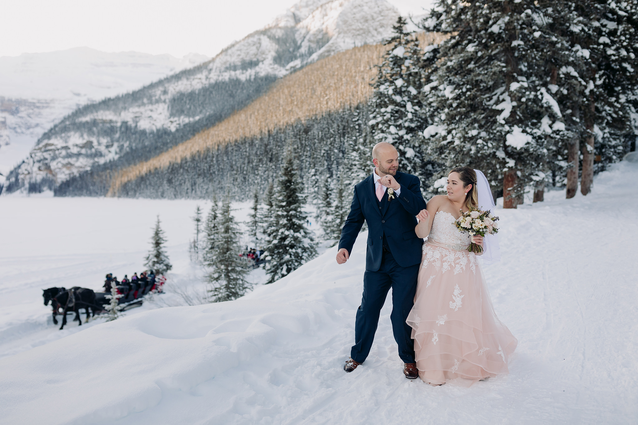 Lake Louise winter elopement on frozen Lake Louise with Bride in pink wedding dress in winter wonderland Super snowy elopement wedding photographed by ENV Photography