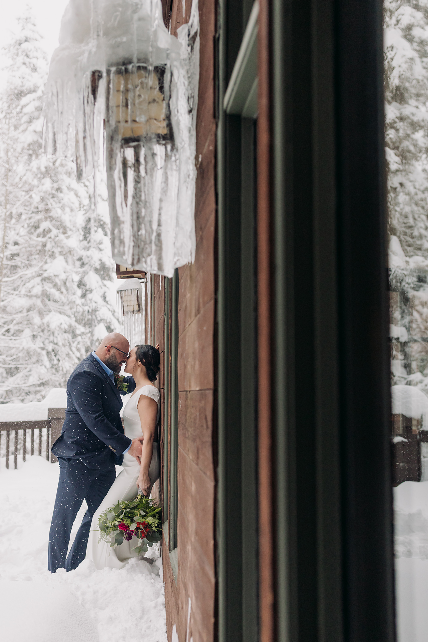 Emerald Lake Lodge winter elopement outdoor bride & groom portraits with falling snow photographed by mountain elopement & wedding photographer ENV Photography