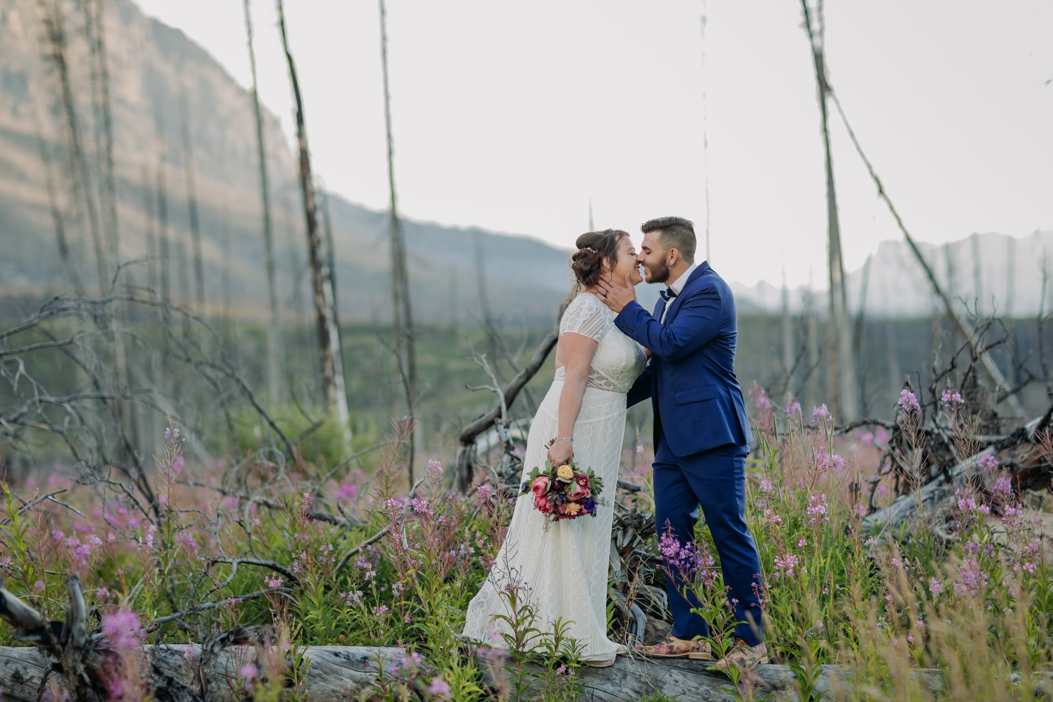 guide to eloping in the Canadian rockiesA Guide to Eloping in the Canadian Rockies | Mountain Wedding photographed by ENV Photography | bride & groom in fireweed on the way to Abraham Lake in burnt out forest