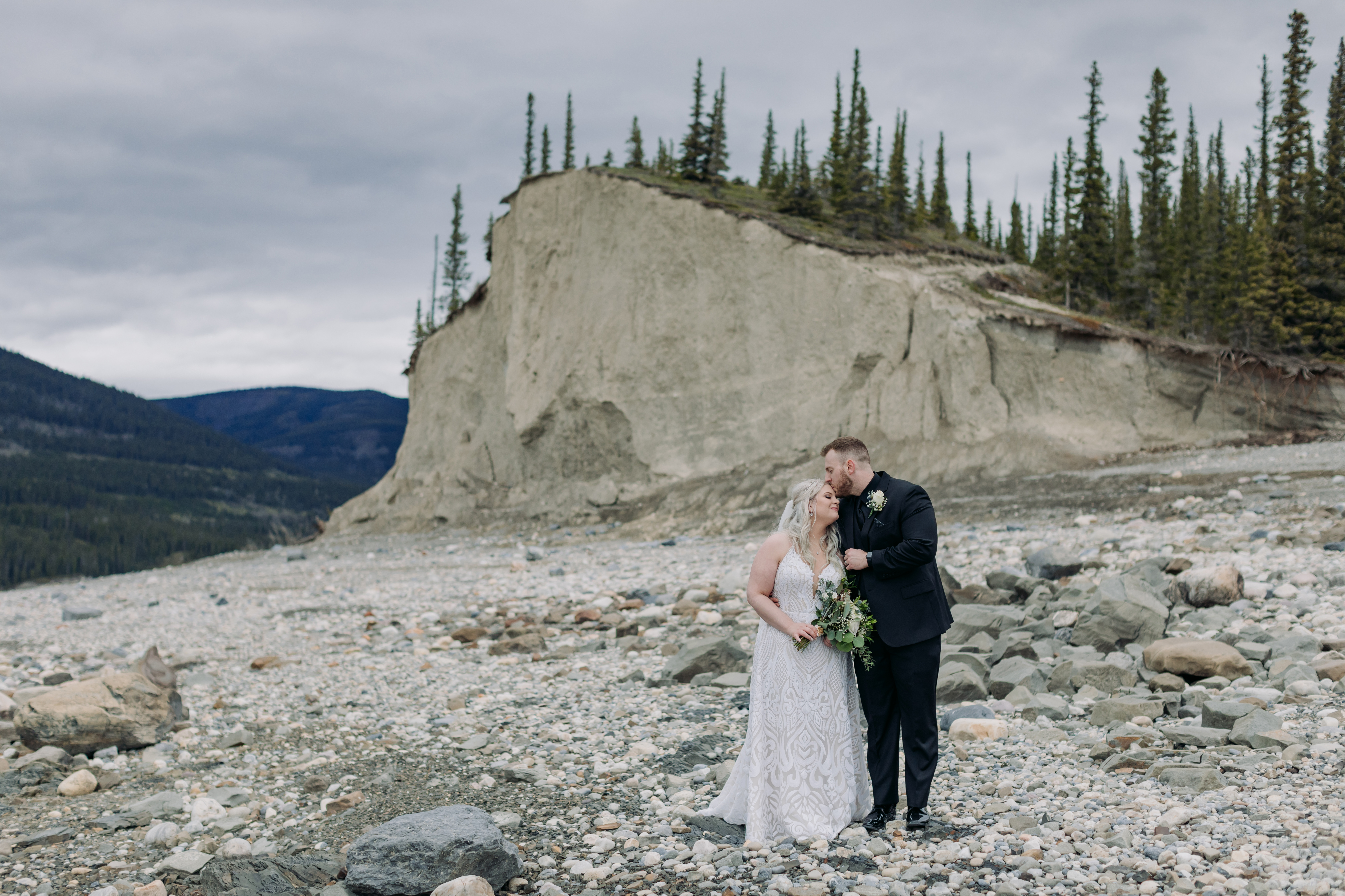 A Guide to Eloping in the Canadian Rockies | Mountain Wedding photographed by ENV Photography | bride & groom on rocky shores of Abraham lake