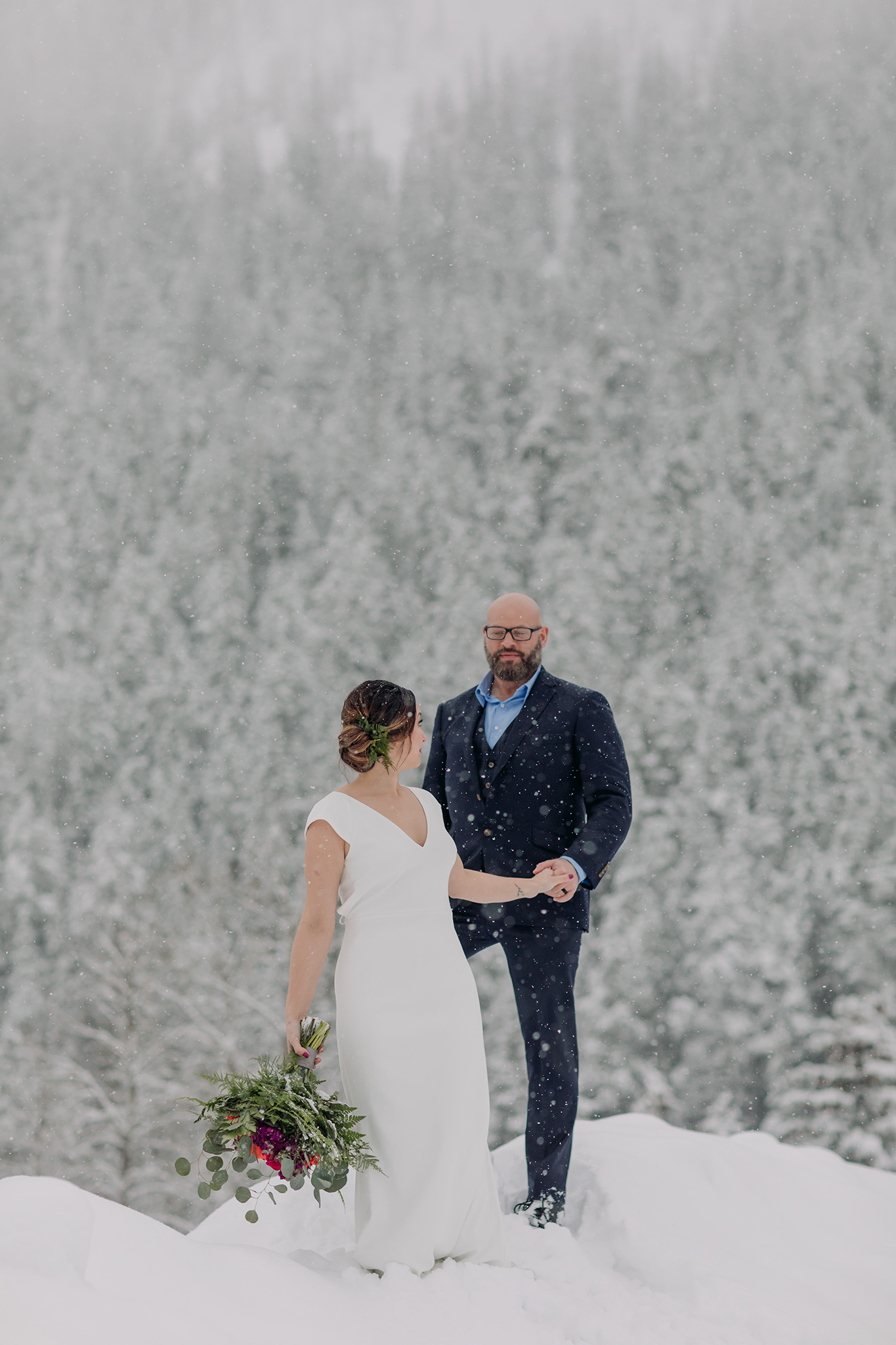 snowy mountain elopement outdoor bride & groom portraits with falling snow photographed by mountain elopement & wedding photographer ENV Photography