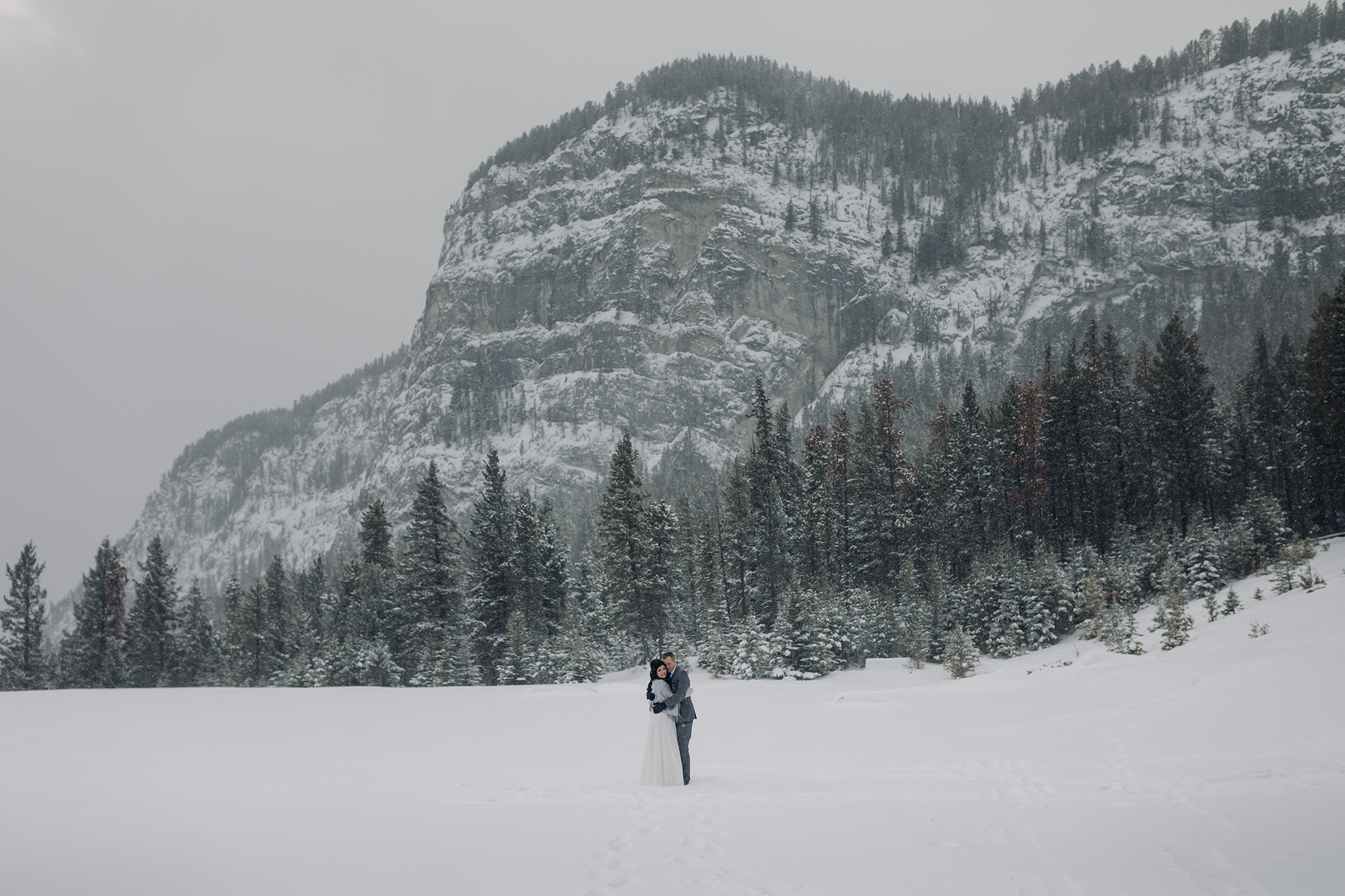 bride groom portraits at Tunnel Mountain Reservoir in a snow storm in Banff National Park in the Canadian Rocky Mountains photographed by ENV Photography