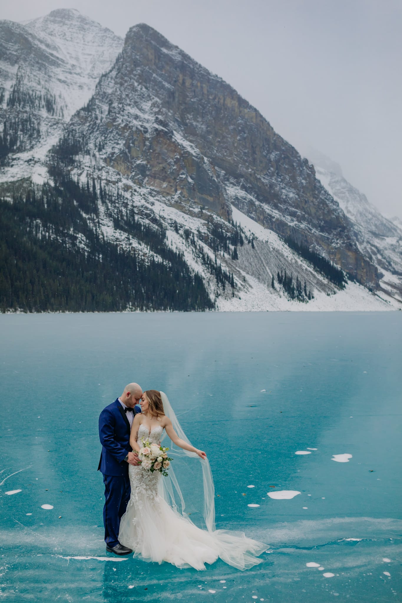 A Guide to Eloping in the Canadian Rockies | Mountain Wedding photographed by ENV Photography | Lake Louise elopement with rare blue ice. Elegant winter wedding in the mountains.