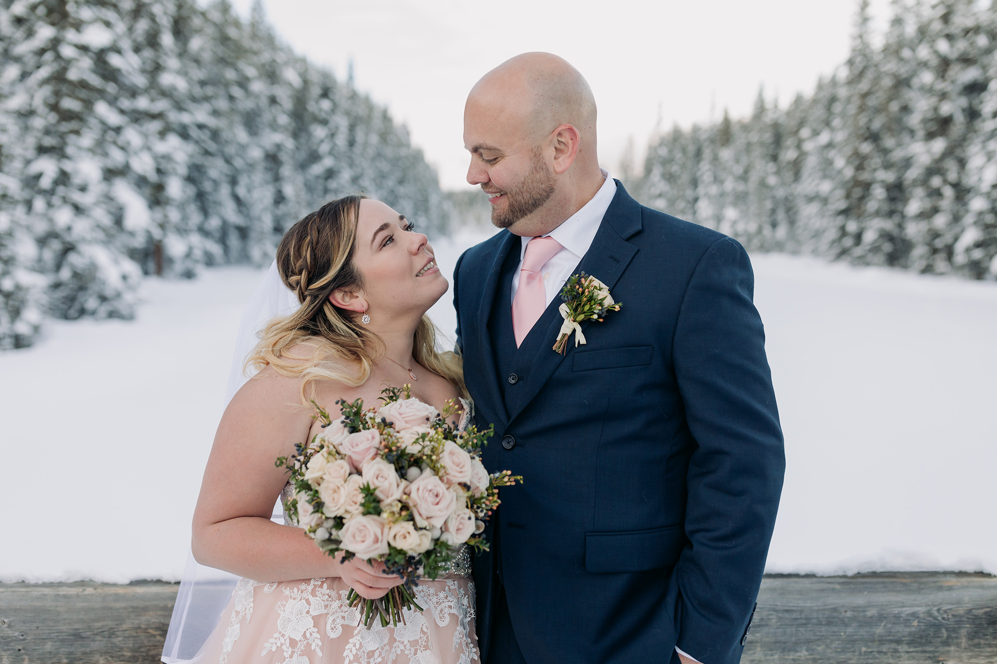 Lake Louise winter elopement on frozen Lake Louise with Bride in pink wedding dress in winter wonderland on the Bow Valley Parkway in Banff National Park photographed by ENV Photography