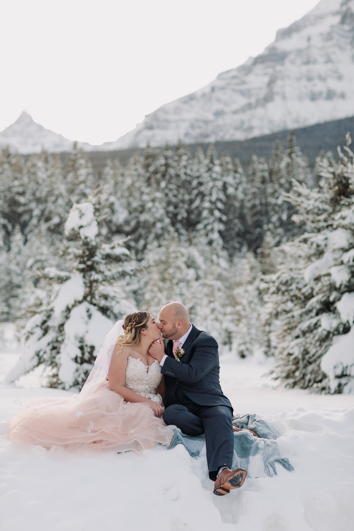 Lake Louise winter elopement on frozen Lake Louise with Bride in pink wedding dress in winter wonderland on the Bow Valley Parkway in Banff National Park photographed by ENV Photography