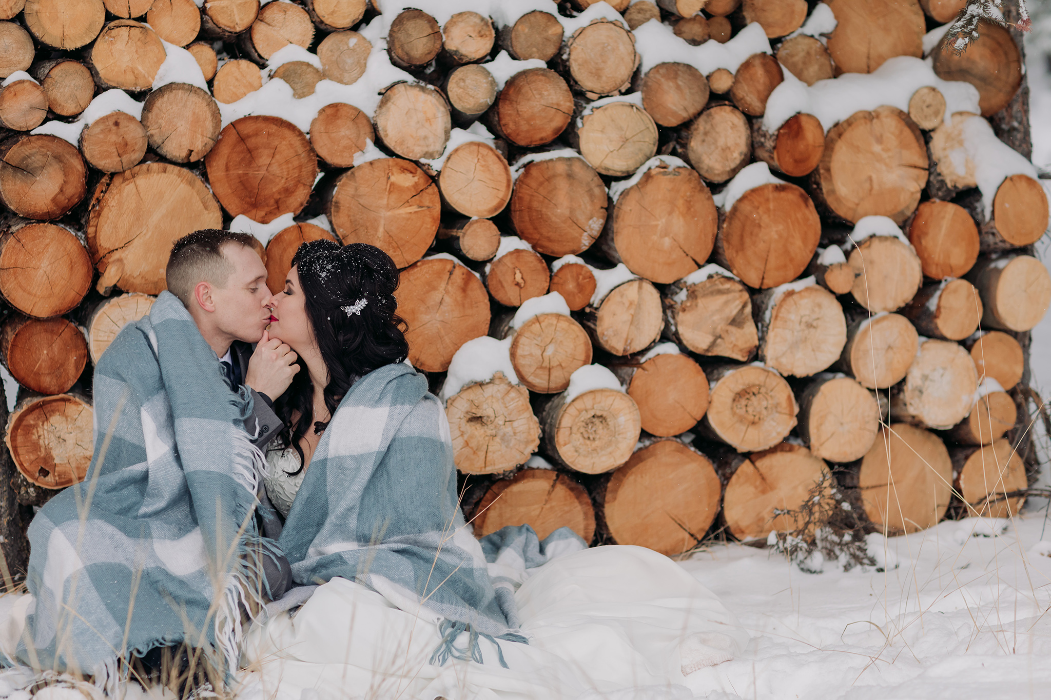wedding portraits at Juniper Hotel woodpile in a snow storm in Banff National Park in the Canadian Rocky Mountains photographed by ENV Photography