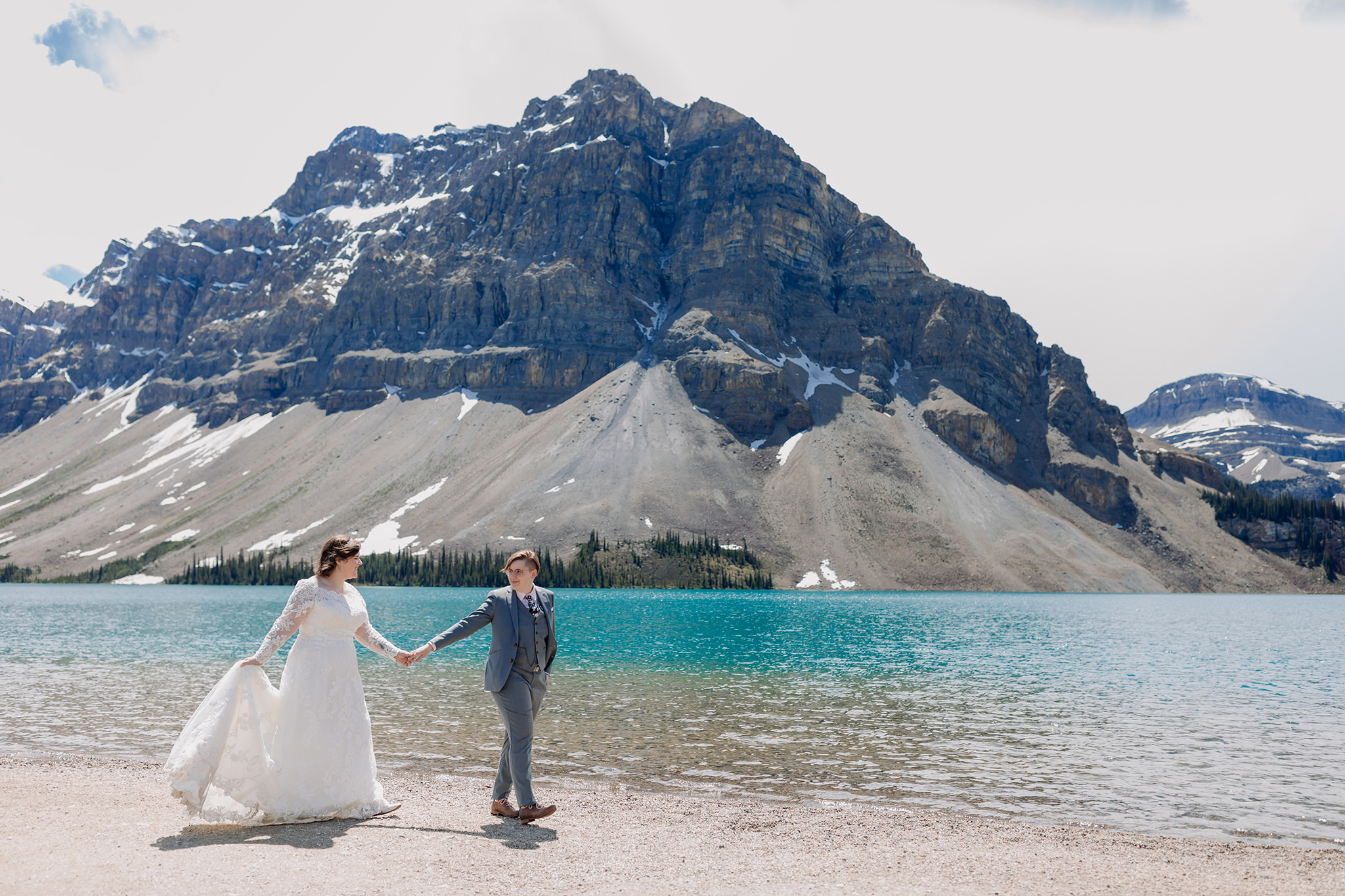 Post-wedding portraits on the shores of Bow Lake. same-sex wedding. Mountain Wedding portraits photographed by ENV Photography. Gay friendly. LGBTQ friendly wedding & elopement photographer.