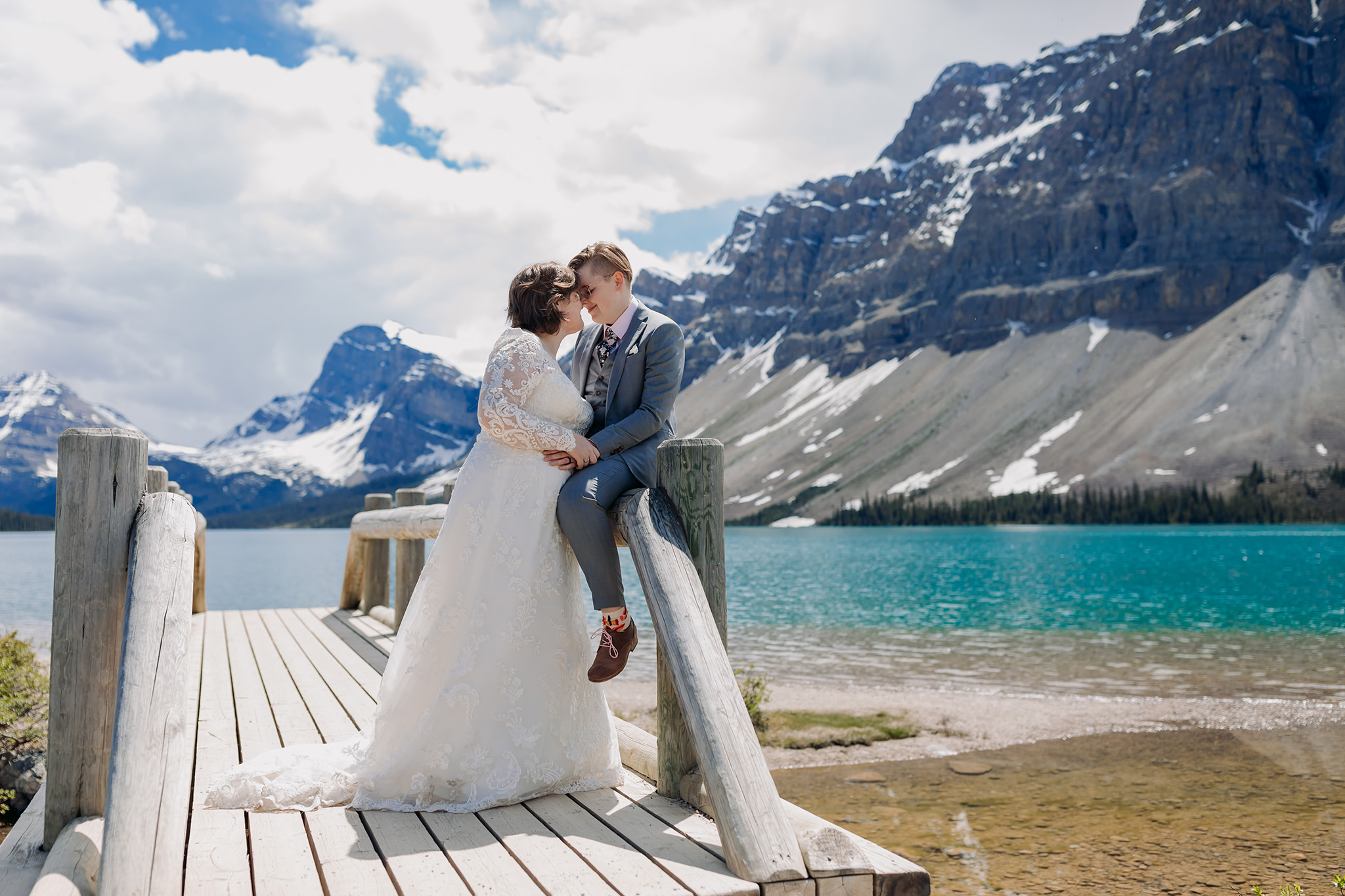 Post-wedding portraits on the shores of Bow Lake. same-sex wedding. Mountain Wedding portraits photographed by ENV Photography. Gay friendly. LGBTQ friendly wedding & elopement photographer.