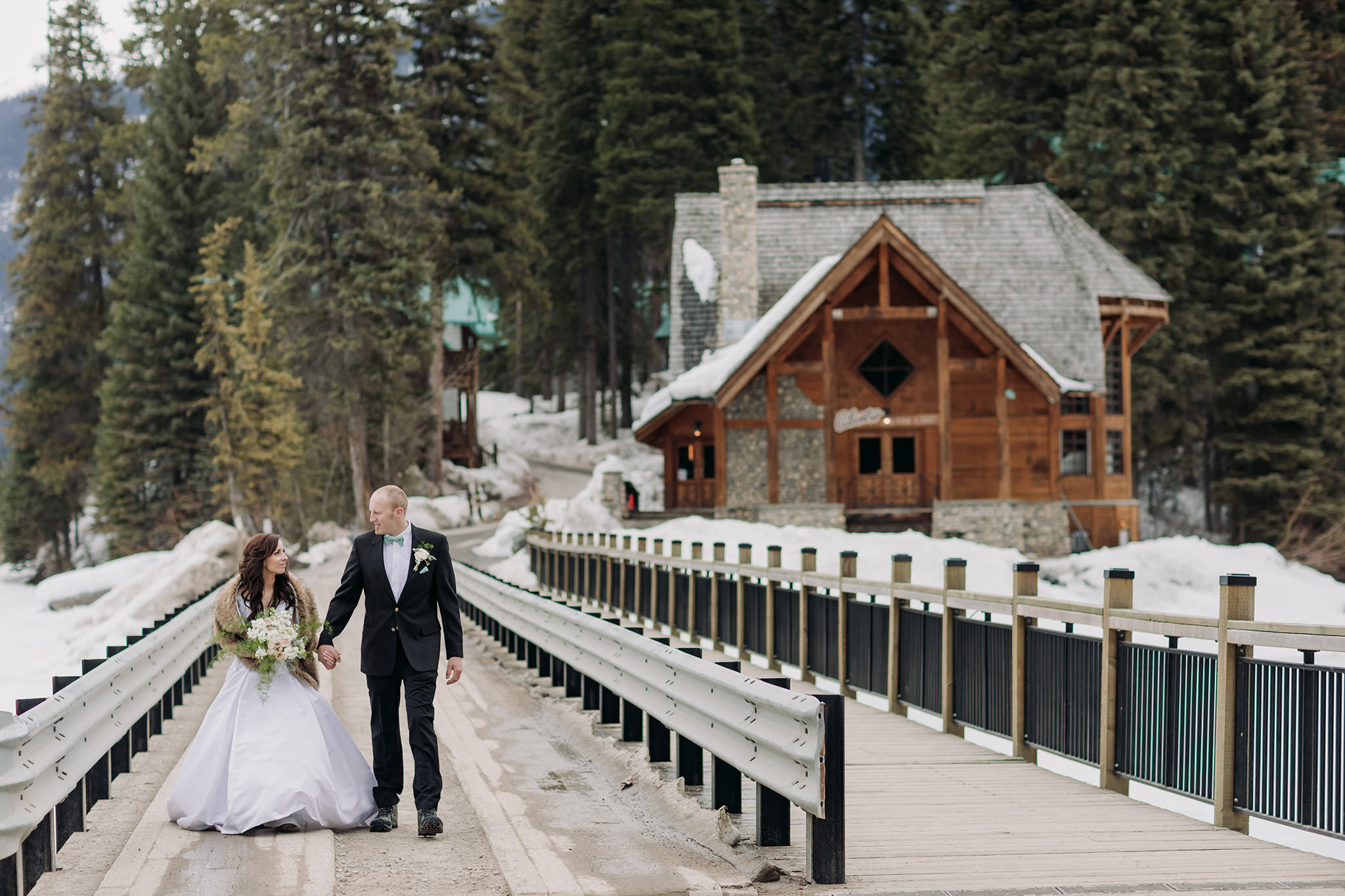emerald lake lodge wedding spring mountain portraits walking across the bridge
