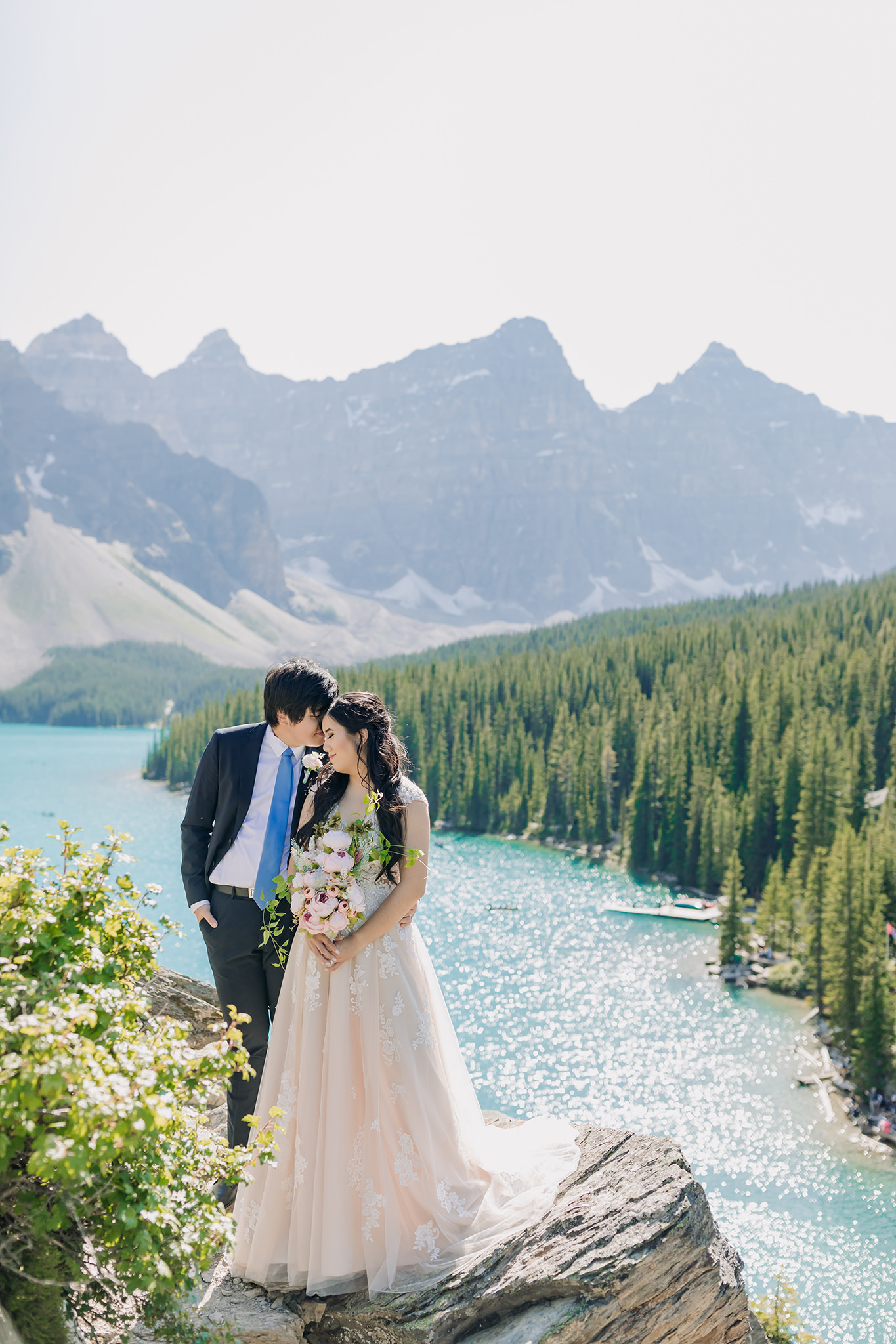 sparkling water sunshine bride groom portraits at Moraine Lake on bright sunny day in Banff National Park photographed by mountain elopement specialist ENV Photography