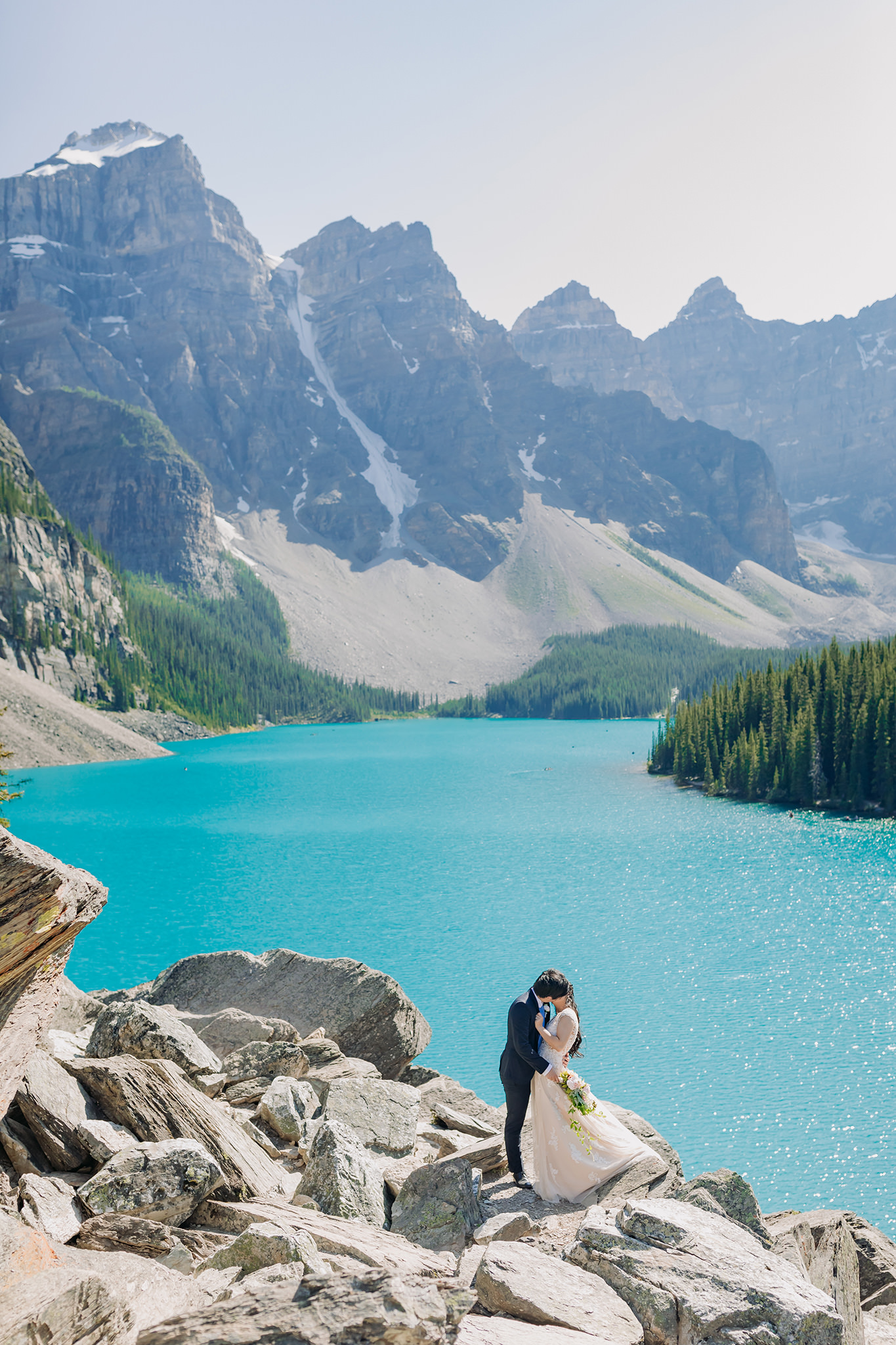 Rocky Mountain wedding tour bride groom portraits at Moraine Lake on bright sunny day in Banff National Park photographed by mountain elopement specialist ENV Photography