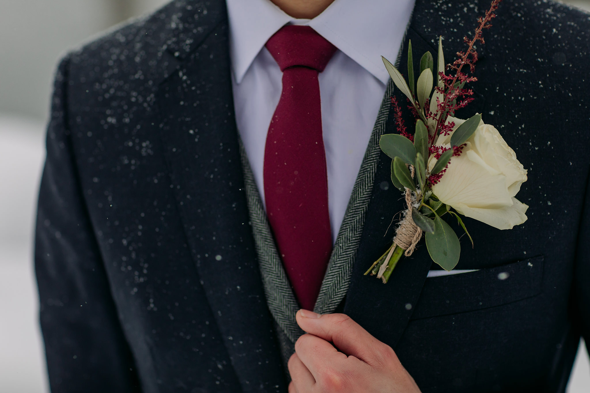 Wedding portraits at Emerald Lake Lodge in Yoho National Park. Mountain wedding in a winter wonderland. Groom boutonniere for winter wedding.