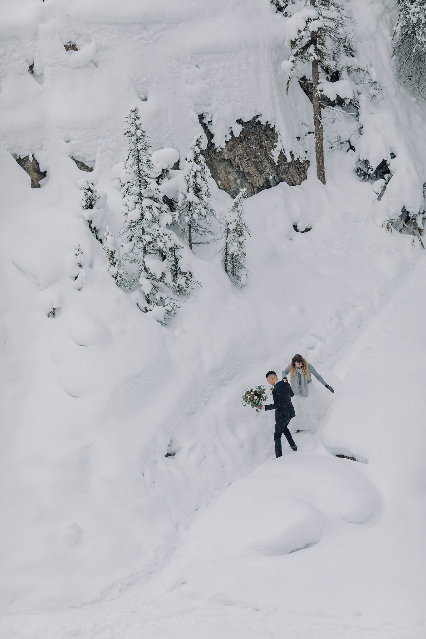 adventurous couple climbing icy trail for their mountain wedding