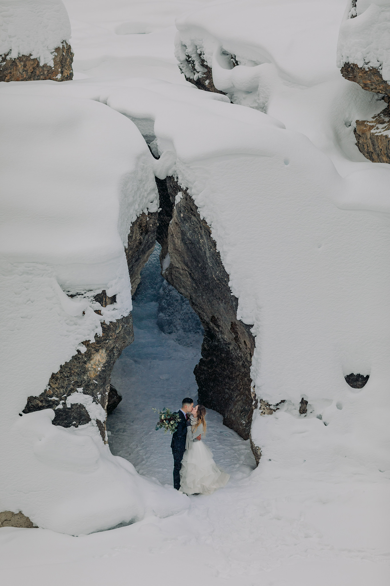 Adventure wedding in frozen ice cave on frozen mountain river in Yoho National park