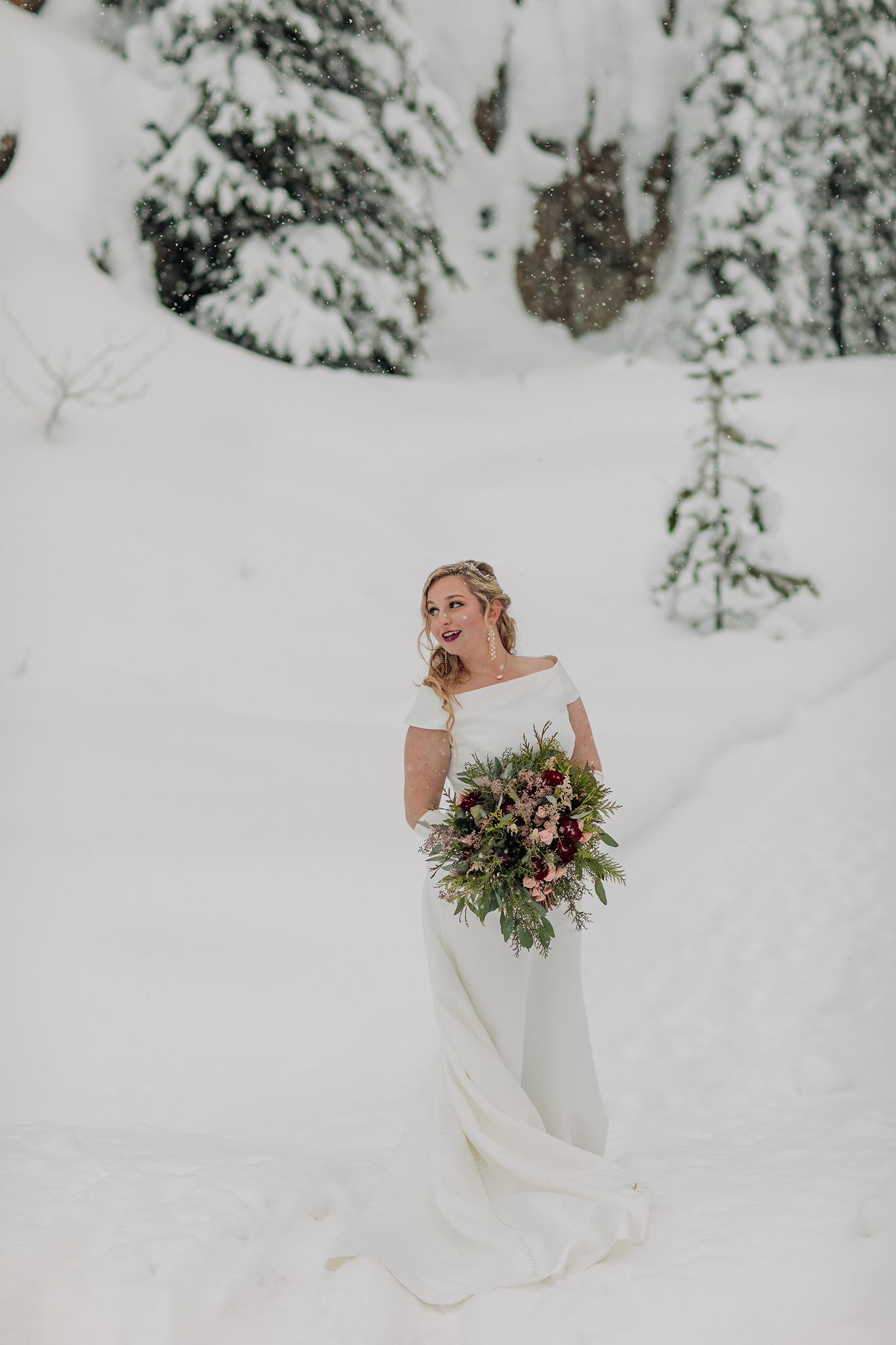 Emerald Lake Lodge outdoor winter wedding bride & groom portraits in a real life snow globe at the natural bridge in Yoho National Park photographed by mountain elopement photographer ENV Photography