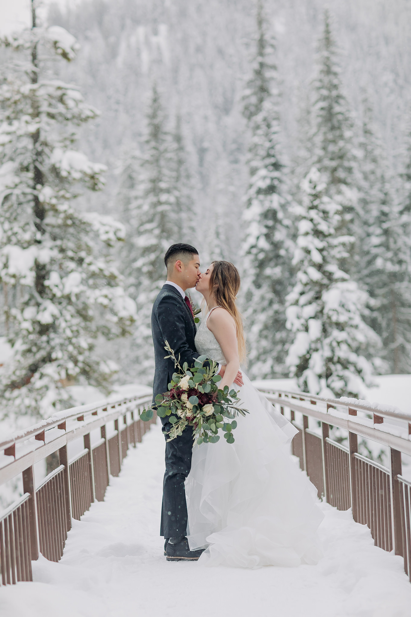 Snowy winter elopement portraits at the natural bridge in Yoho National Park. Mountain wedding in a winter wonderland. 