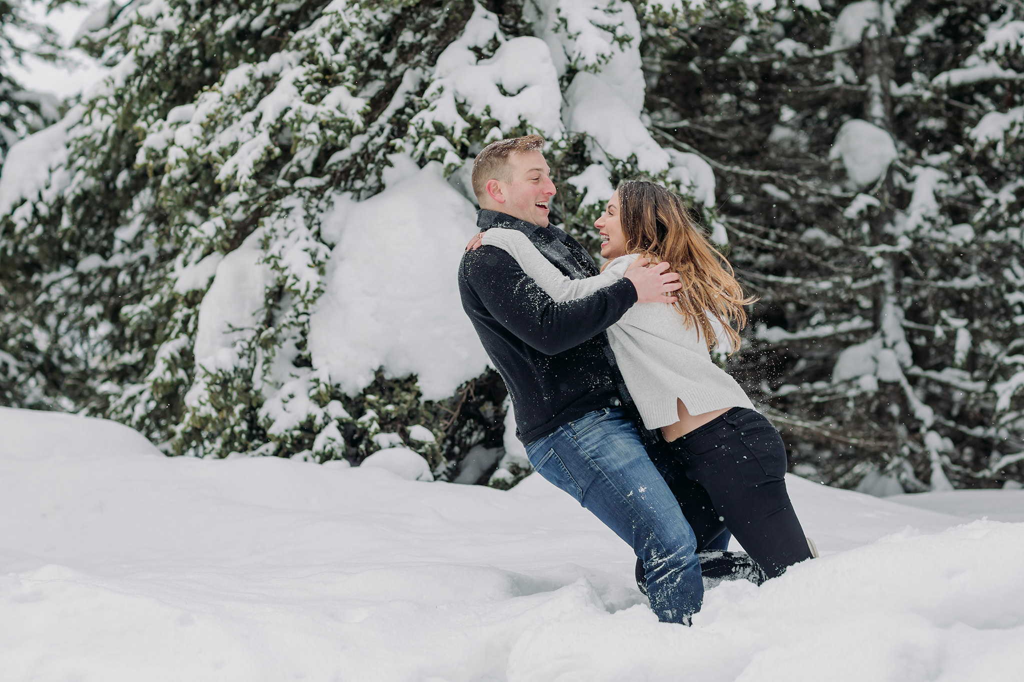fun playful couples photos in the mountains snowy play fight in winter