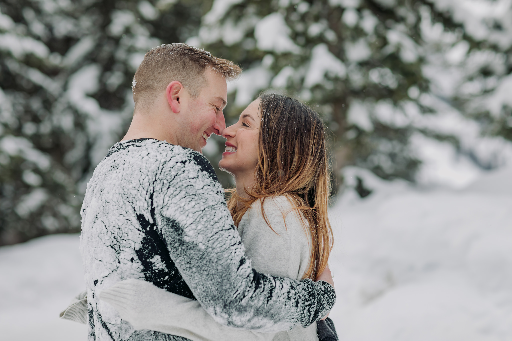 fun playful couples photos in the mountains snowy play fight in winter