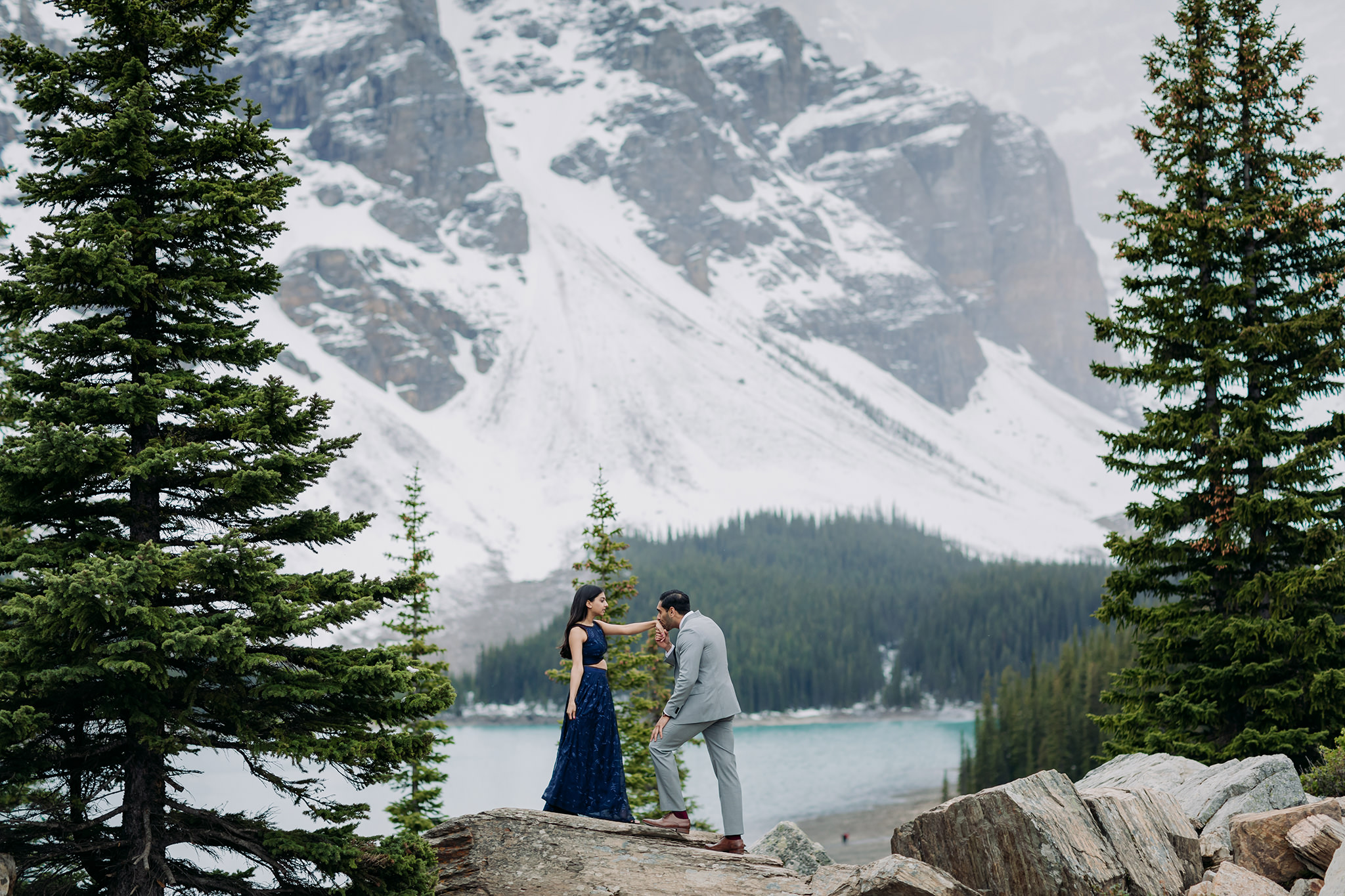 Moraine Lake Stormy Engagement on the rock pile with a formal style turqoise water & mountain views