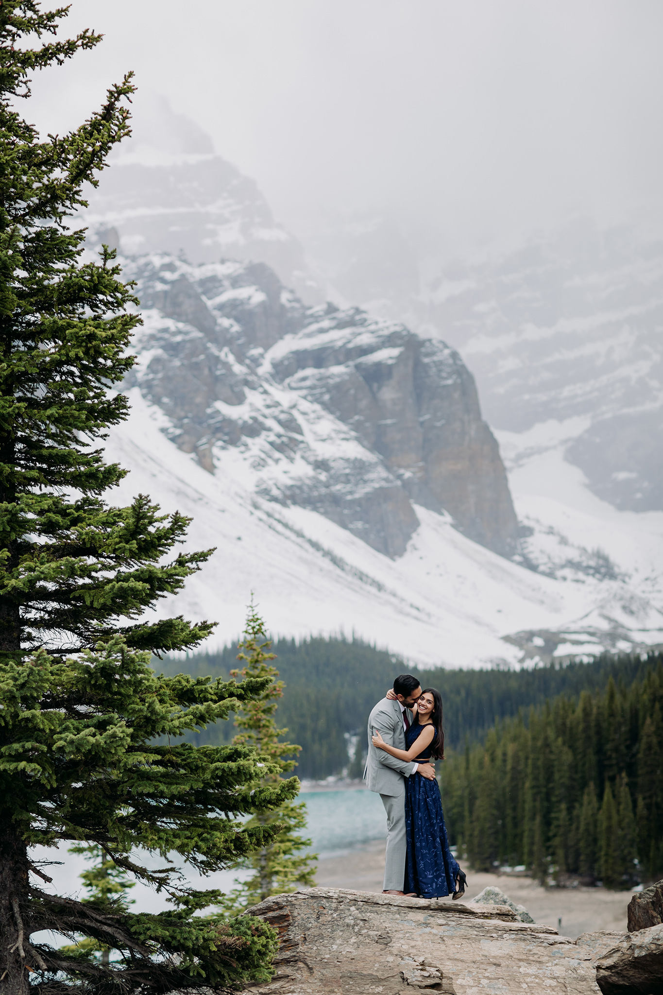 Moraine Lake Stormy Engagement on the rock pile with a formal style turqoise water & mountain views