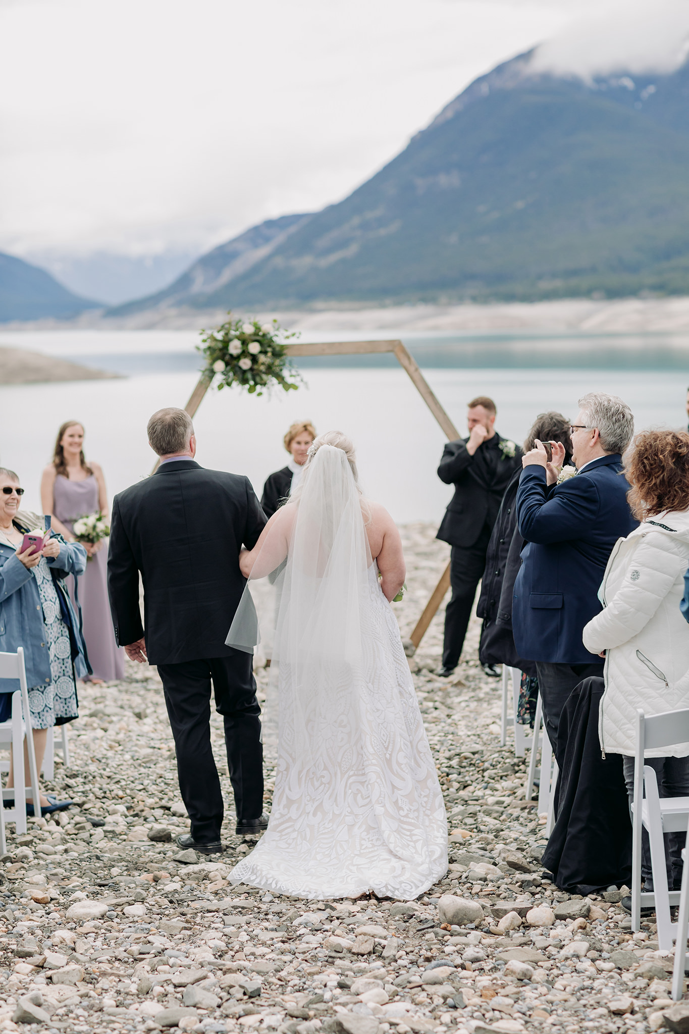 Abraham Lake Spring Mountain wedding with outdoor wedding ceremony with blue waters & mountains in the distance