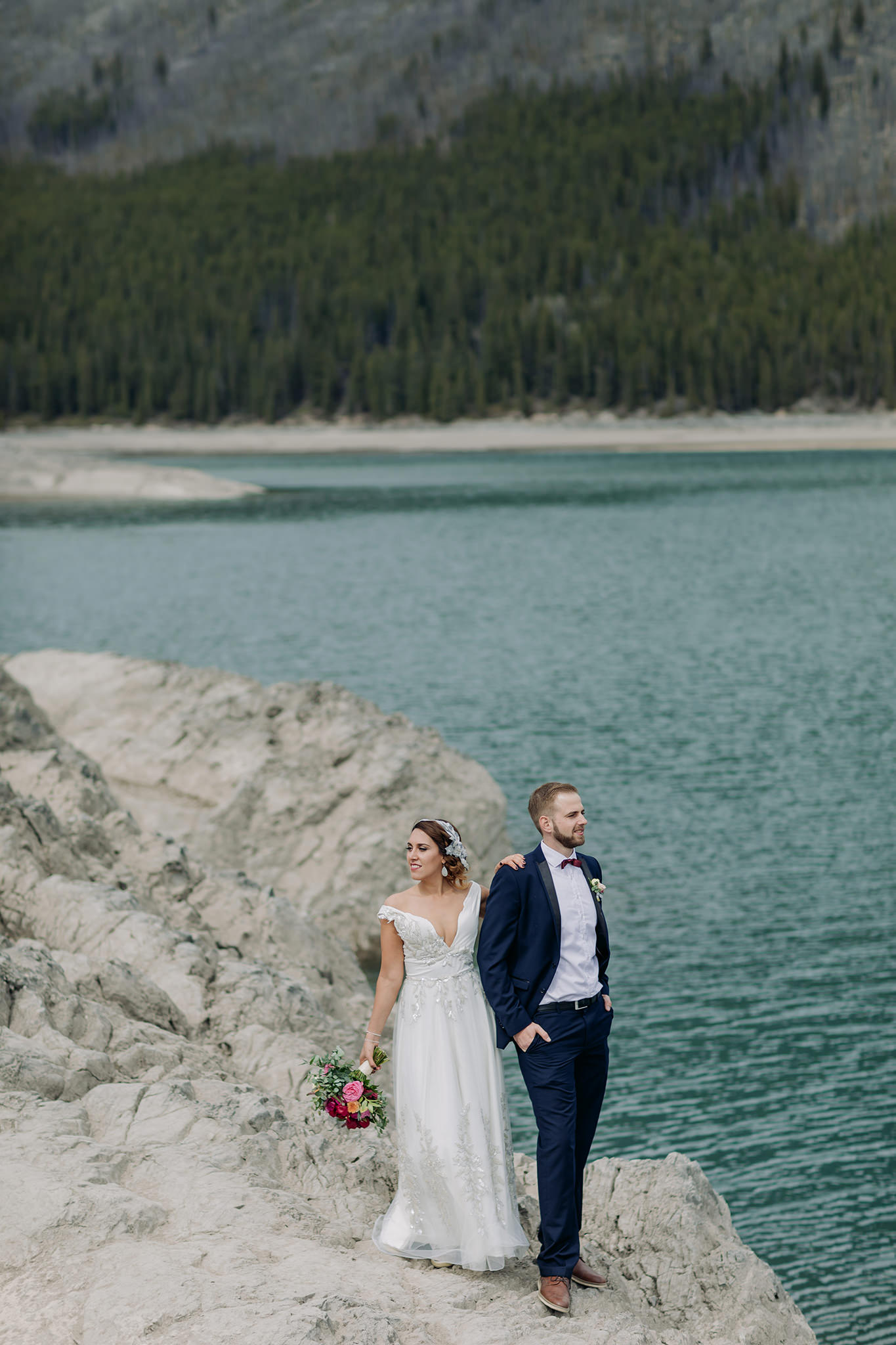 Lake Minnewanka mountain wedding photos in spring with blue mountain lake & gorgeous views