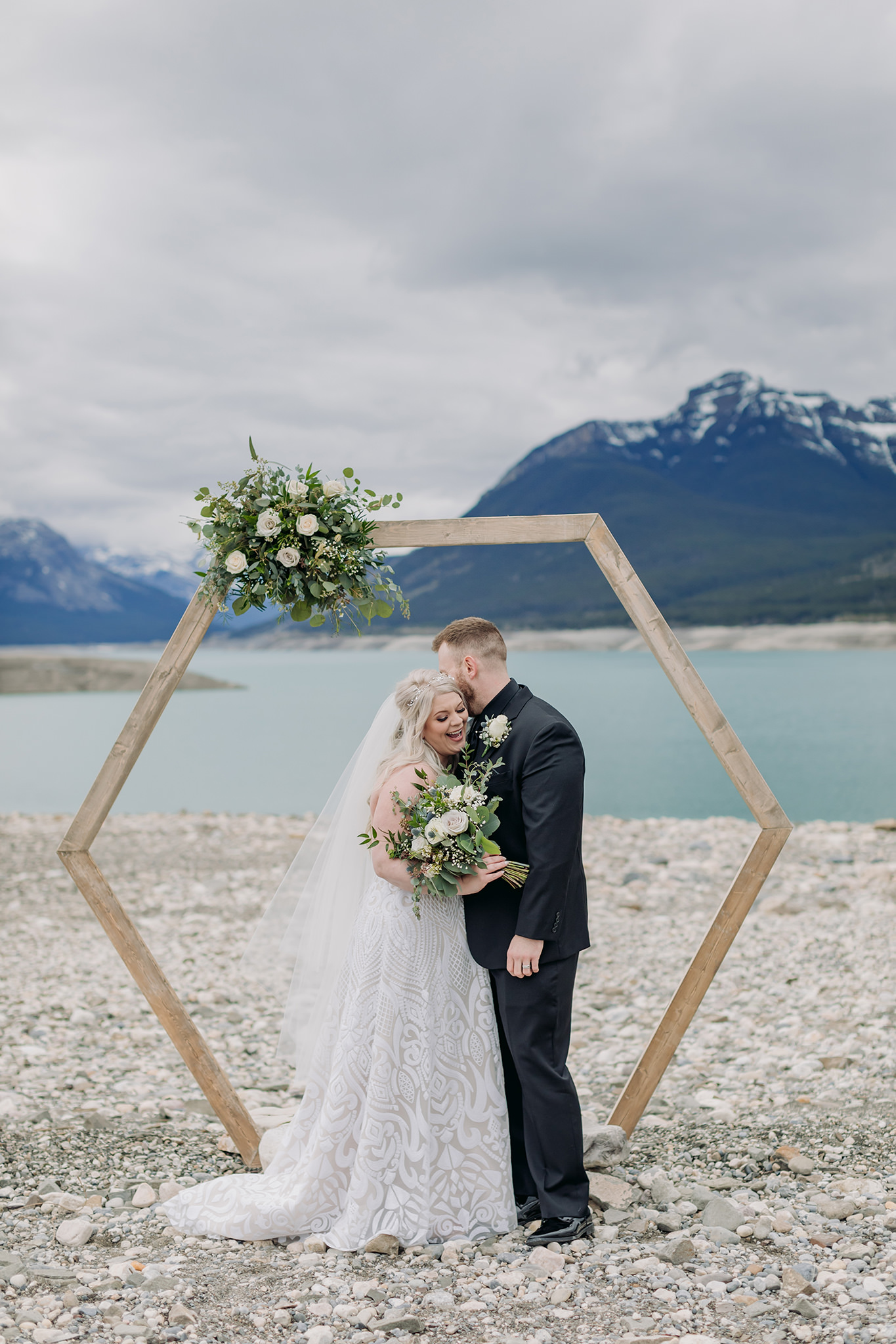 Abraham Lake Spring Mountain wedding with outdoor wedding ceremony with blue waters & mountains in the distance