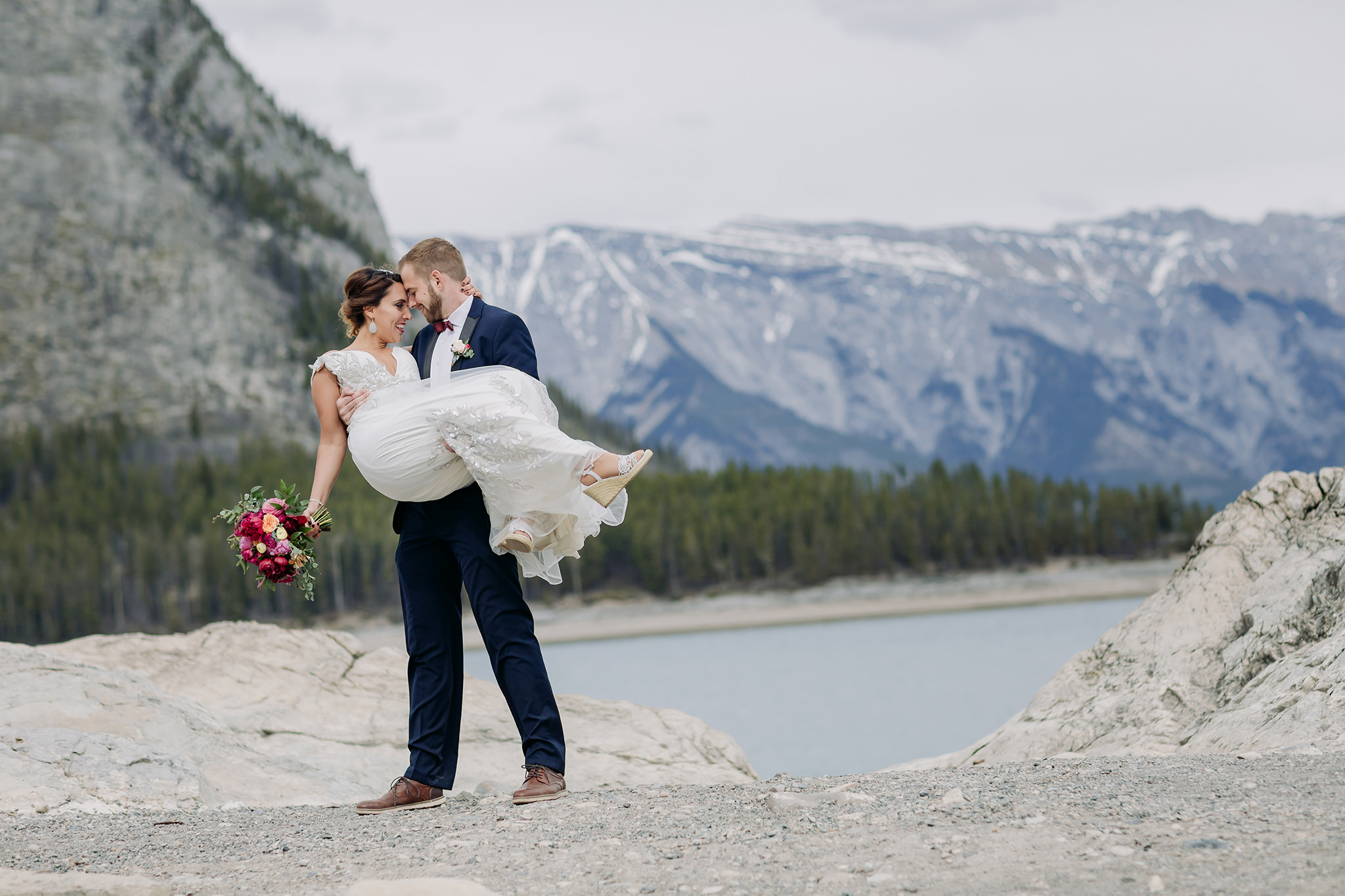 Lake Minnewanka mountain wedding photos in spring with blue mountain lake & gorgeous views