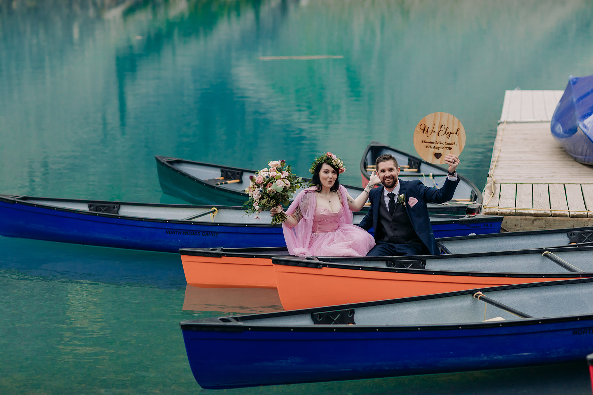 how to elope at moraine lake wedding portraits with colorful canoes & turquoise water