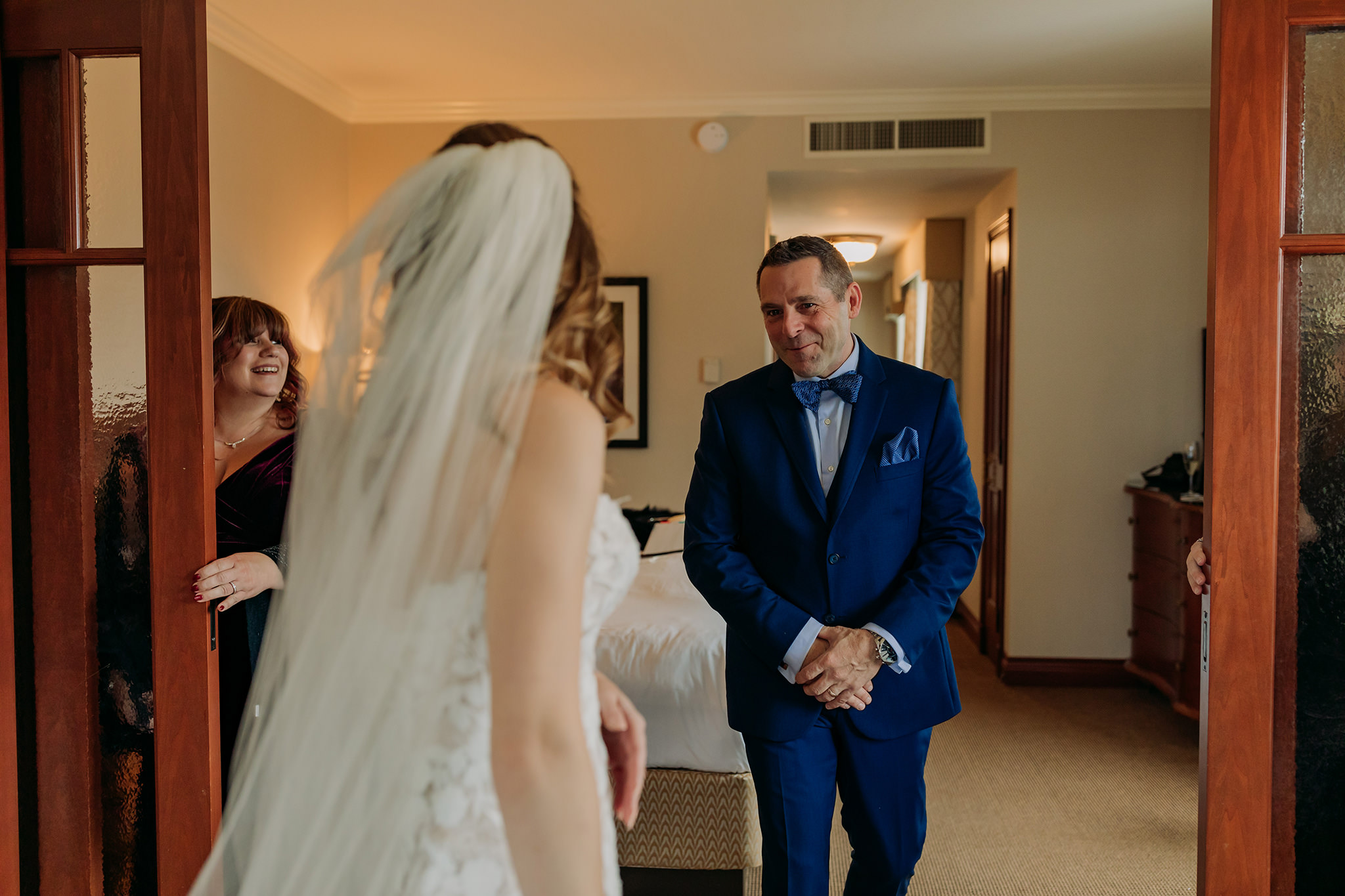 Bride getting ready for her outdoor winter wedding in a suite at the Fairmont Chateau Lake Louise in the Canadian Rocky Mountains first look with dad