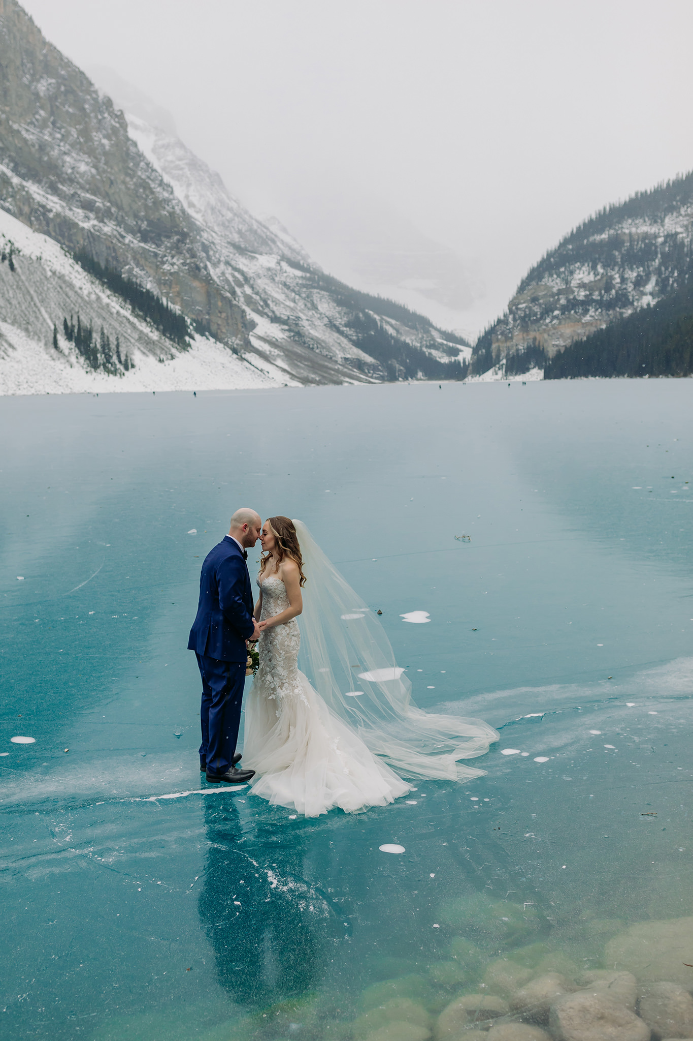 Epic blue ice backdrop for outdoor winter wedding at Lake Louise in the Canadian Rocky Mountains