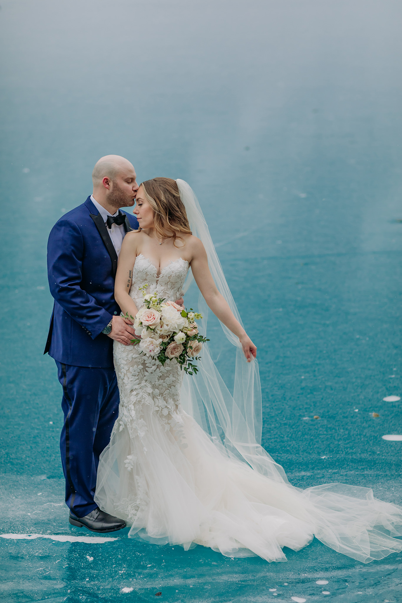 Epic blue ice backdrop for outdoor winter wedding at Lake Louise in the Canadian Rocky Mountains