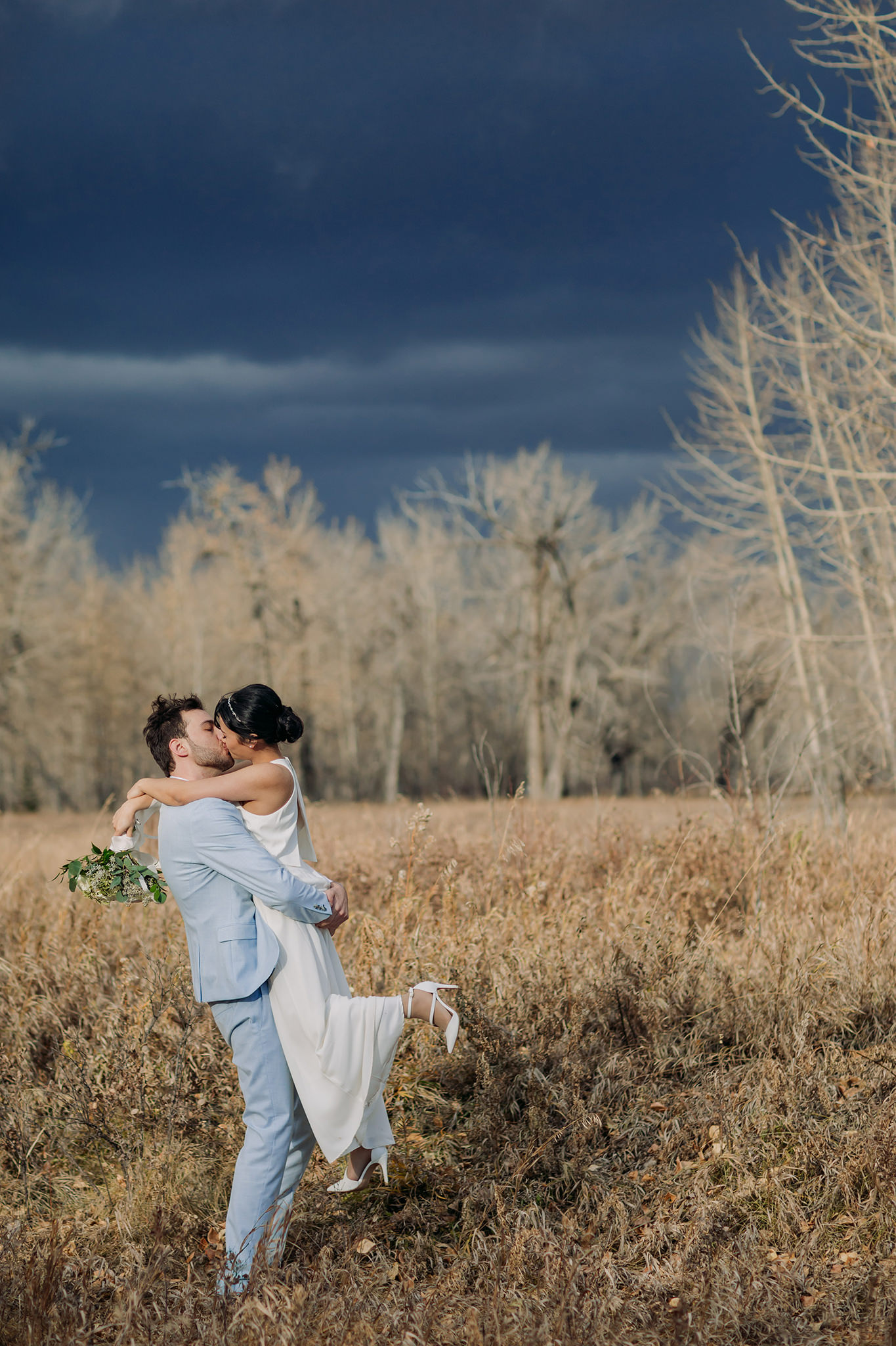 bride & groom portraits in Fish Creek Park on a stormy October day for intimate Calgary wedding photography