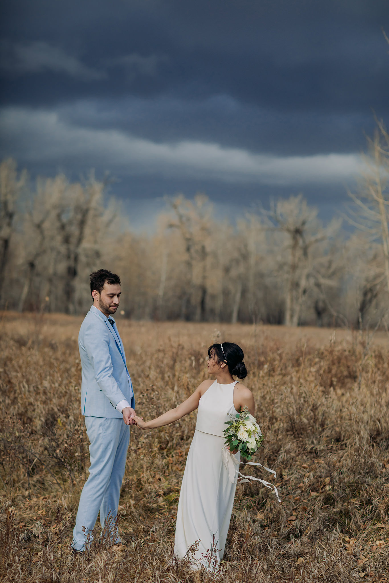 bride & groom portraits in Fish Creek Park on a stormy October day for intimate Calgary wedding photography