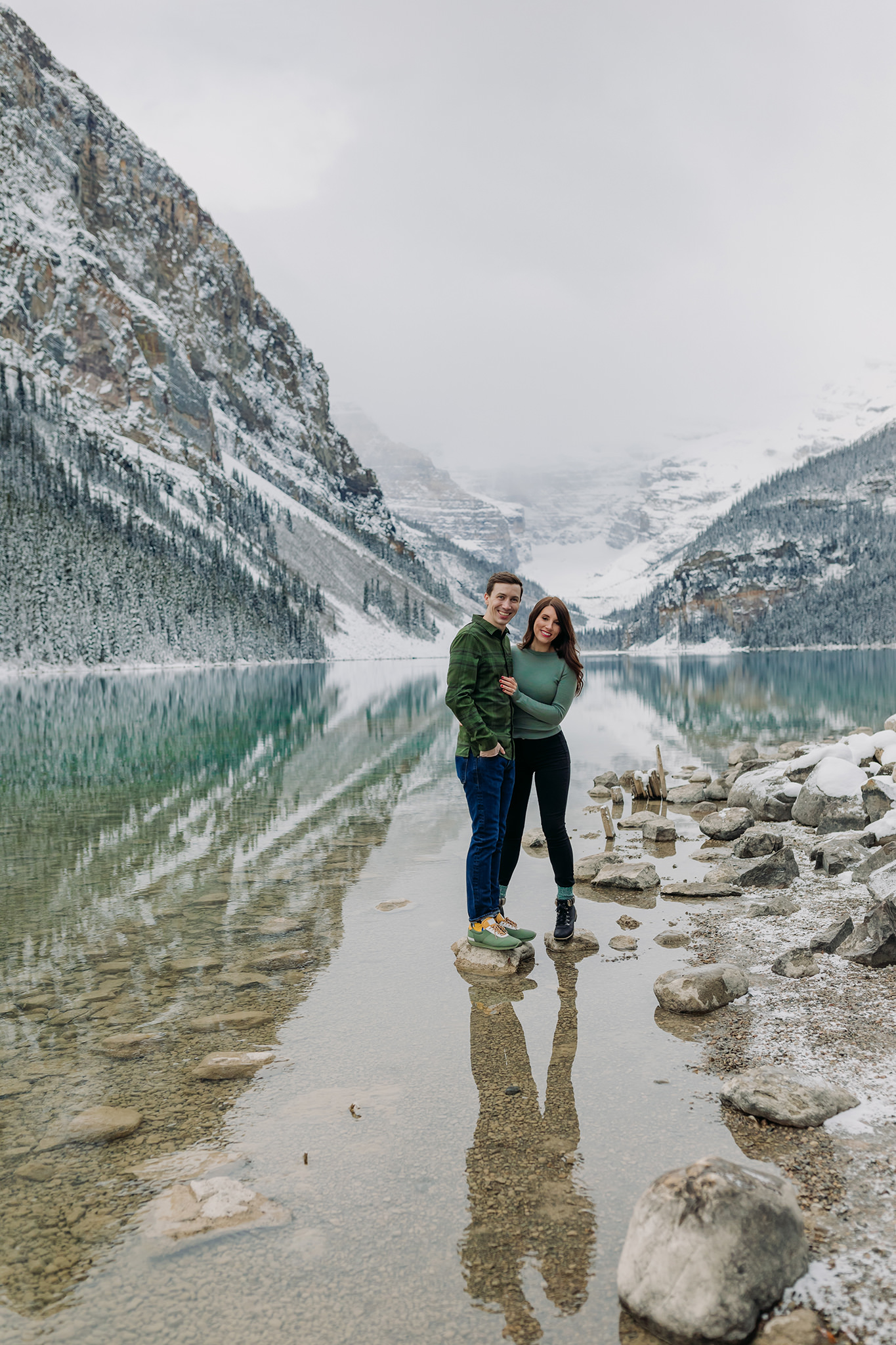 Casual Canadian Rocky Mountain engagement session in autumn with fresh snow and stunning turquoise water