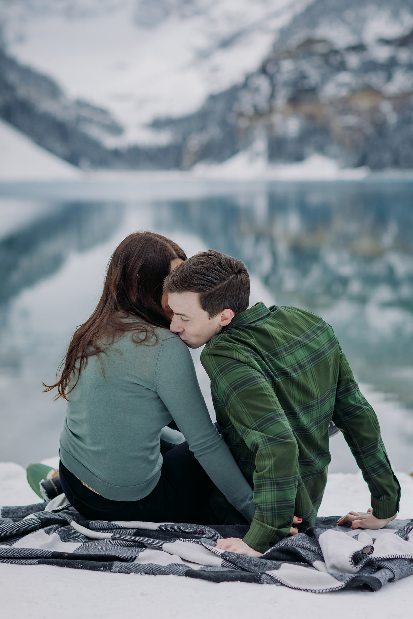 Casual Canadian Rocky playful Mountain engagement session in autumn with fresh snow and stunning turquoise water