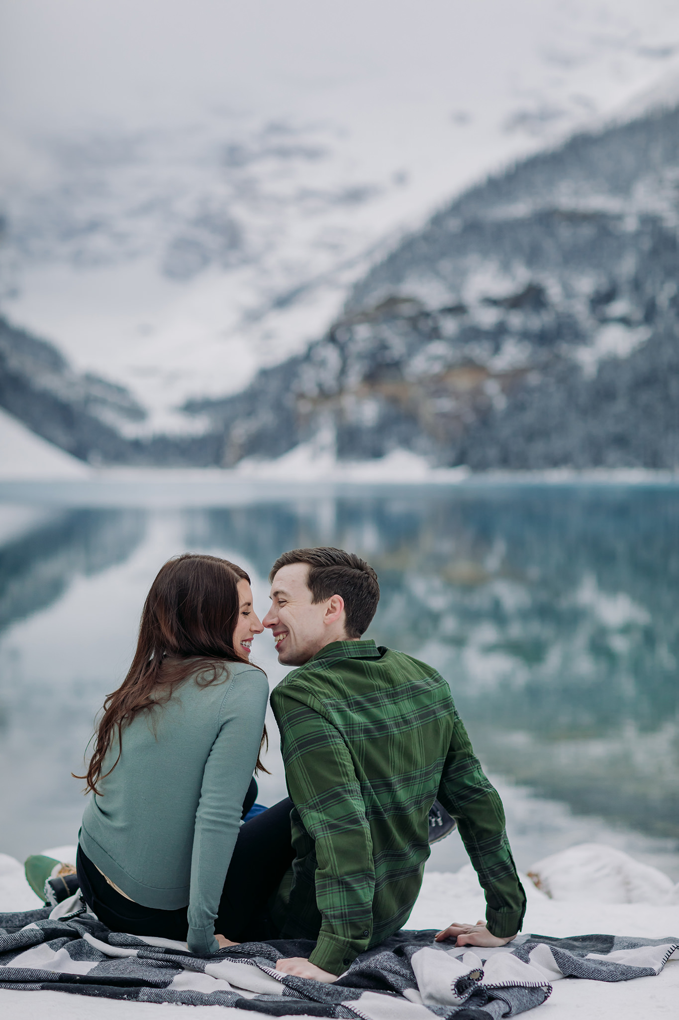 Casual Canadian Rocky playful Mountain engagement session in autumn with fresh snow and stunning turquoise water