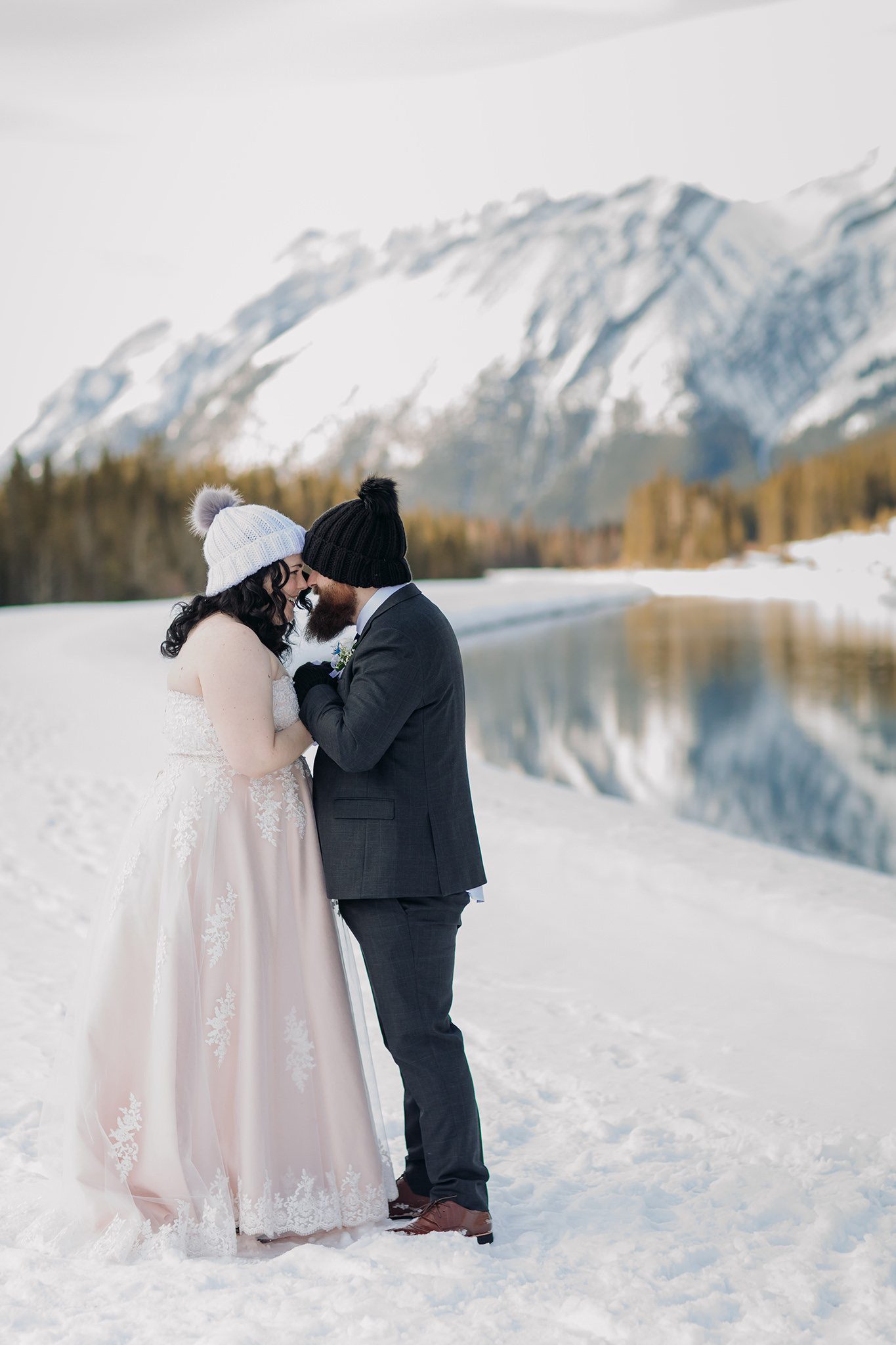 Falcon Crest Lodge wedding Canmore winter wedding photos bride & groom at Goat Pond in Kananaskis photographed by ENV Photography with hats mittens