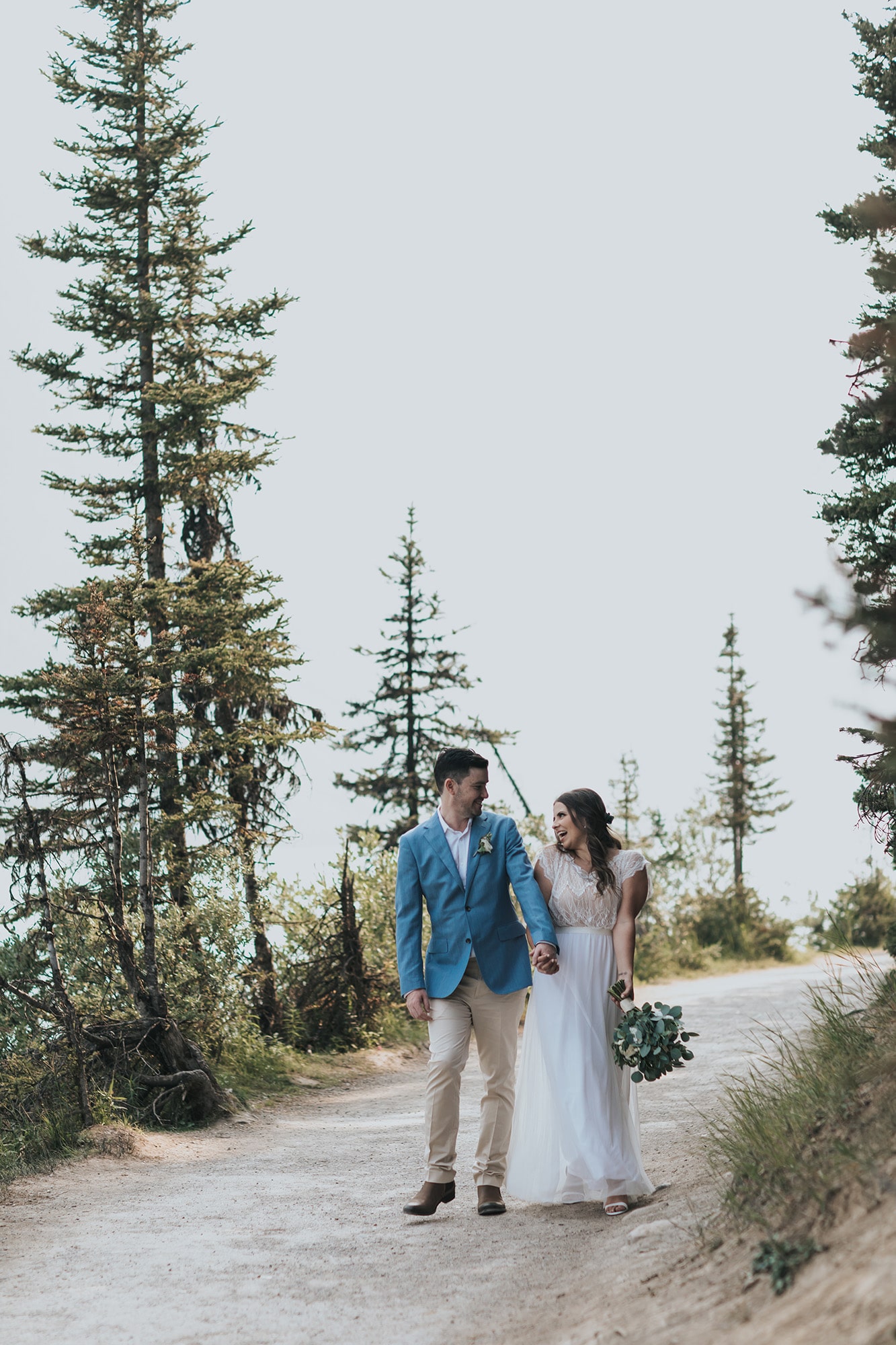 Bride & Groom Walking the wooded trail during wildfire season in the Canadian Rockies